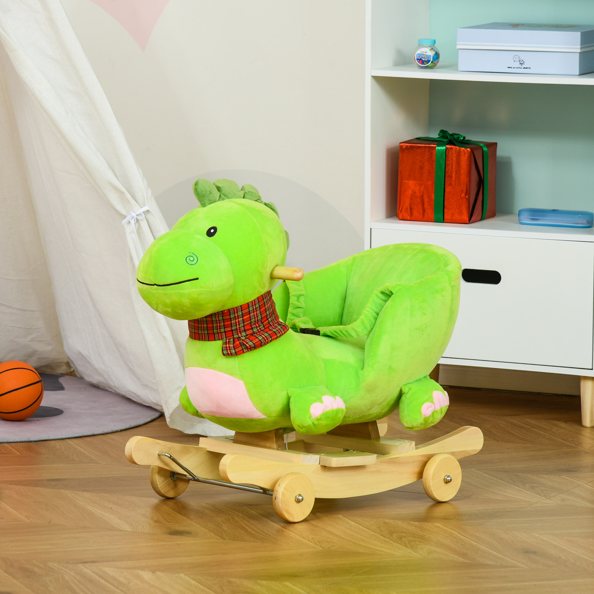 Una sedia a dondolo di peluche verde a forma di dinosauro con guide in legno e ruote piccole.