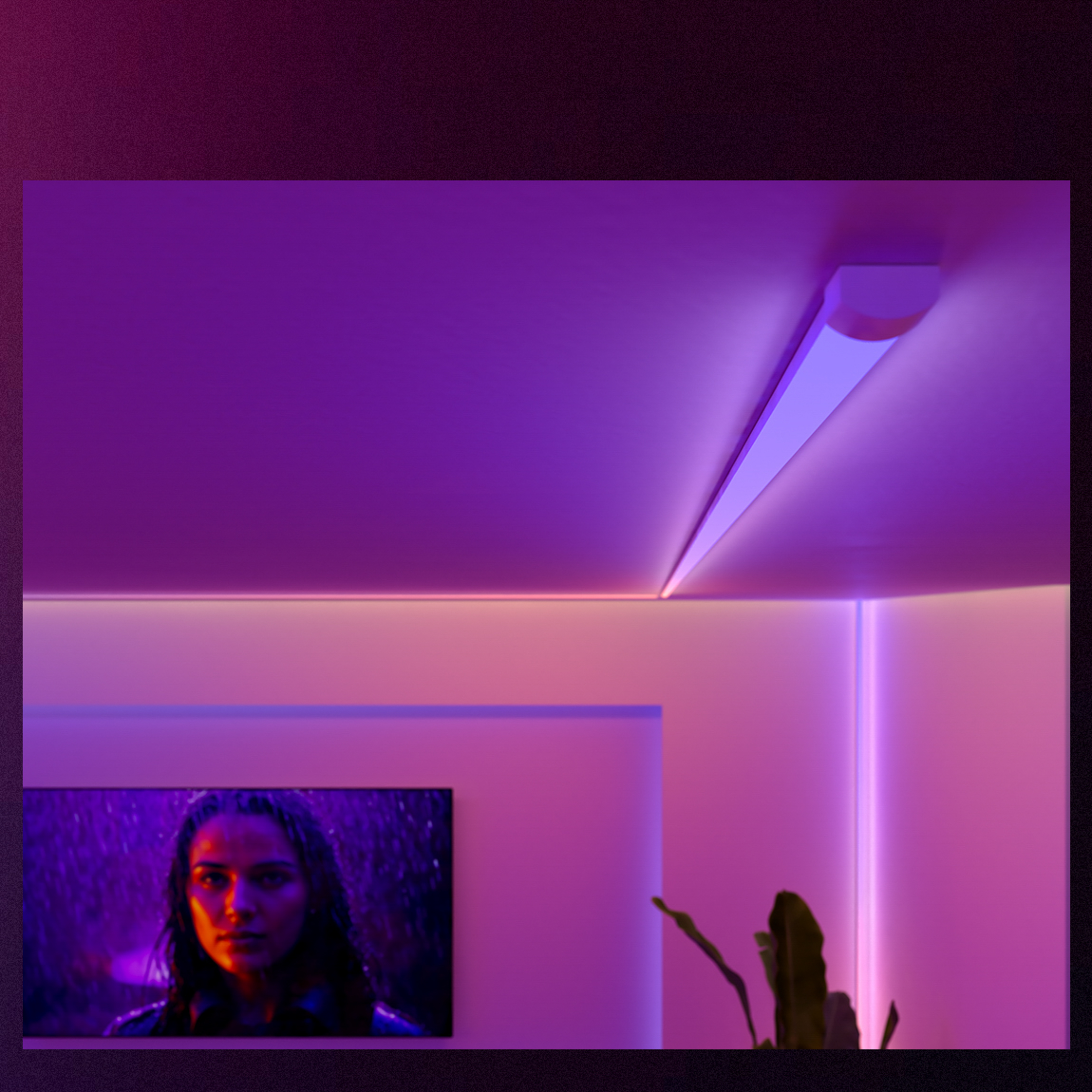 Una stanza illuminata da luce ambientale viola e rosa con uno schermo TV e una pianta nell'angolo.