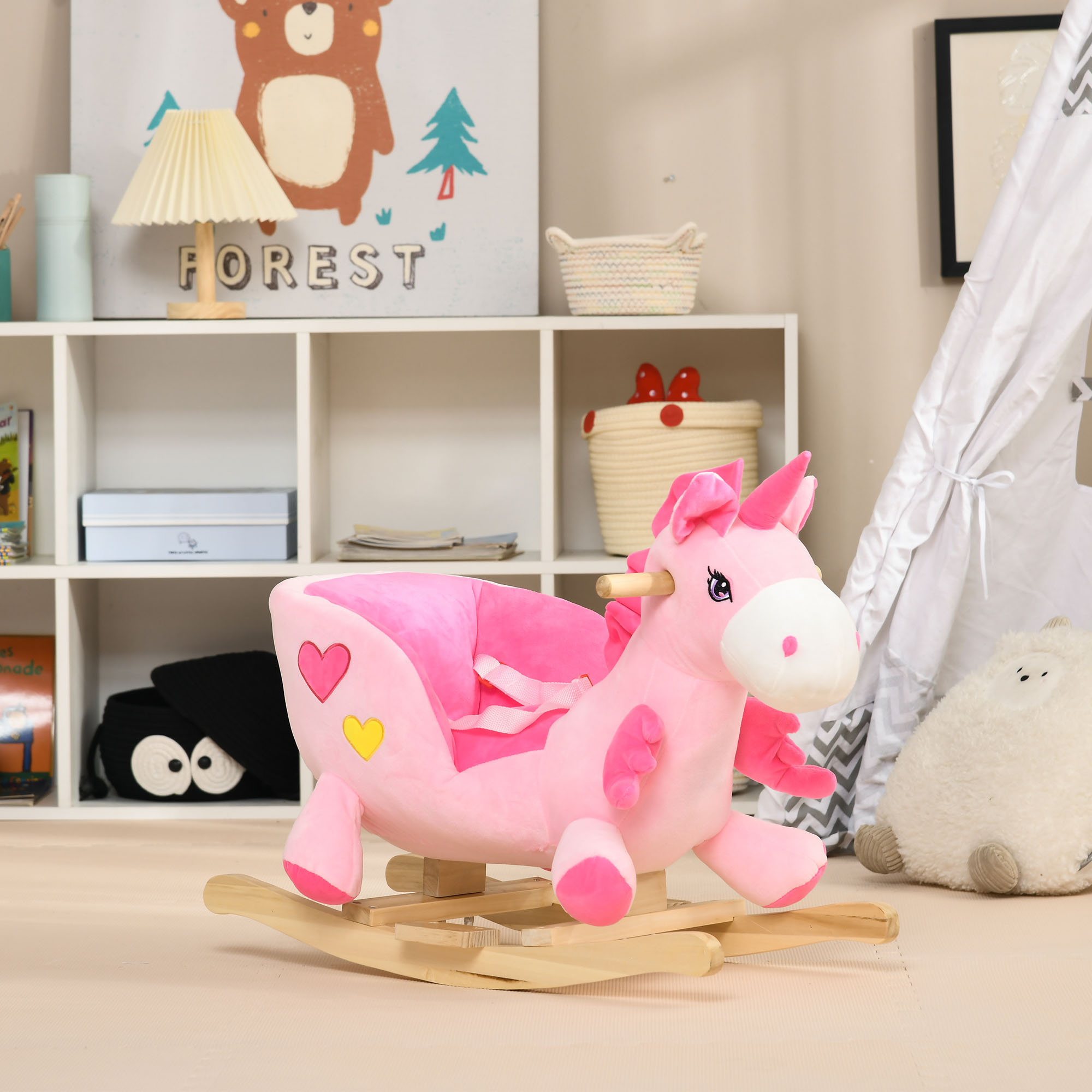 Una sedia a dondolo in peluche rosa a forma di unicorno su base in legno in una stanza dei giochi con scaffali e tenda.