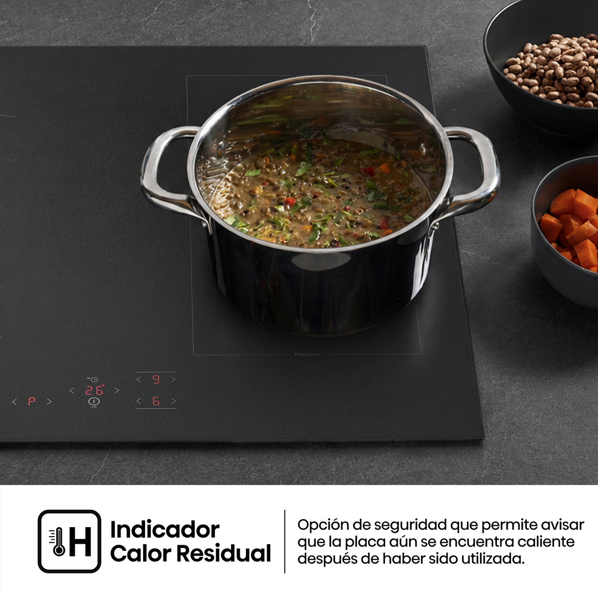 Una olla de sopa en una encimera de inducción negra, con cuencos de judías y zanahorias cerca.