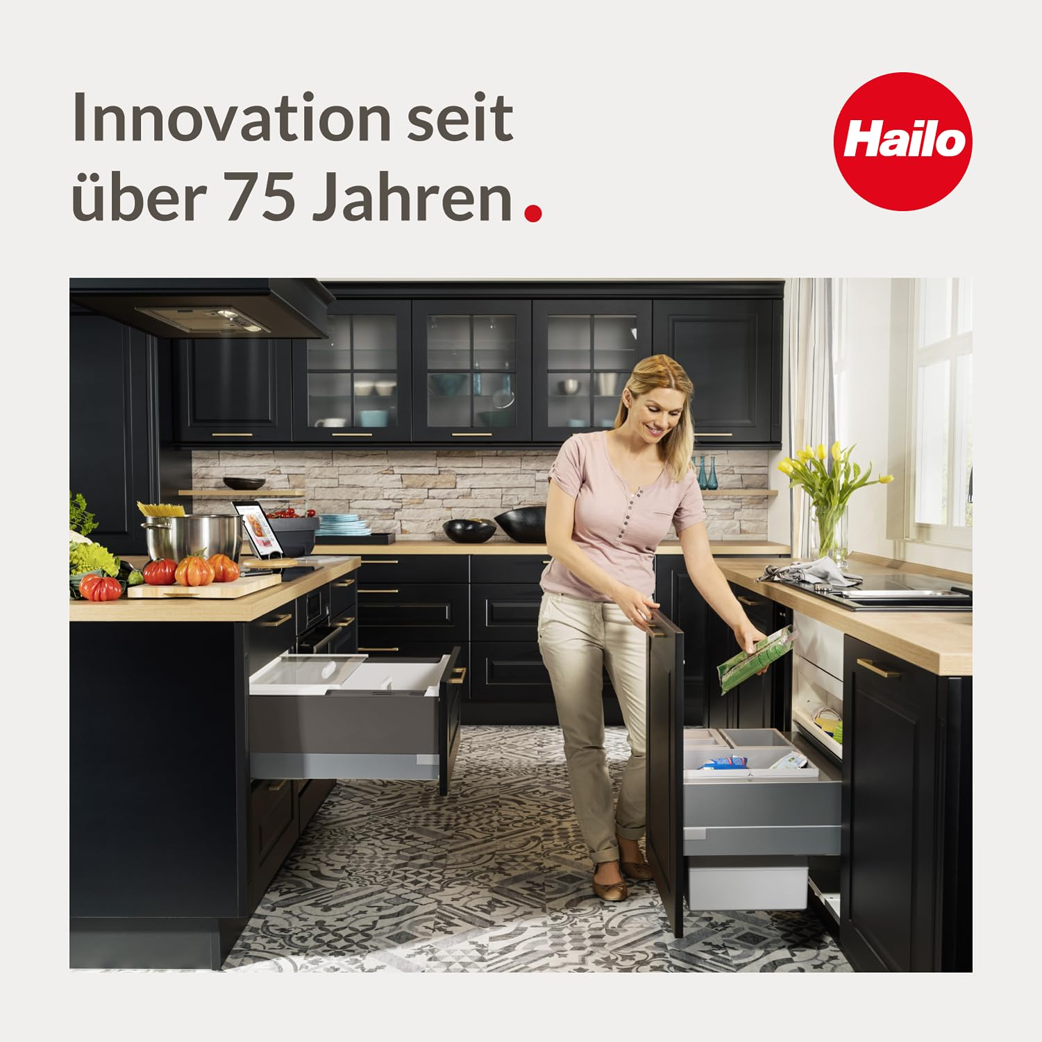 Eine Frau in einer modernen Küche öffnet einen Unterschrank zur Mülltrennung, mit Text oben links und Hailo-Logo.