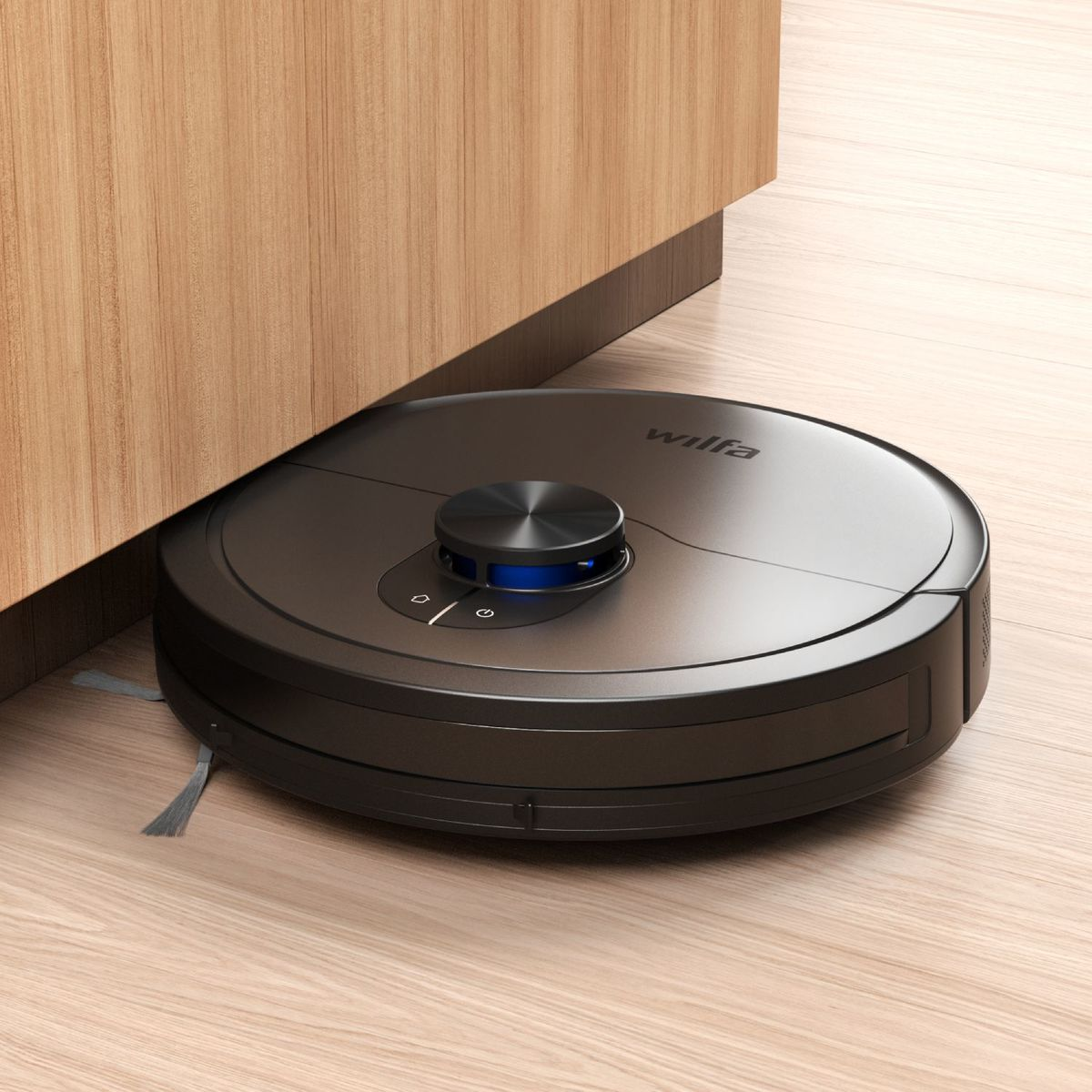 Un robot aspirapolvere Wilfa nero pulisce il pavimento in legno.