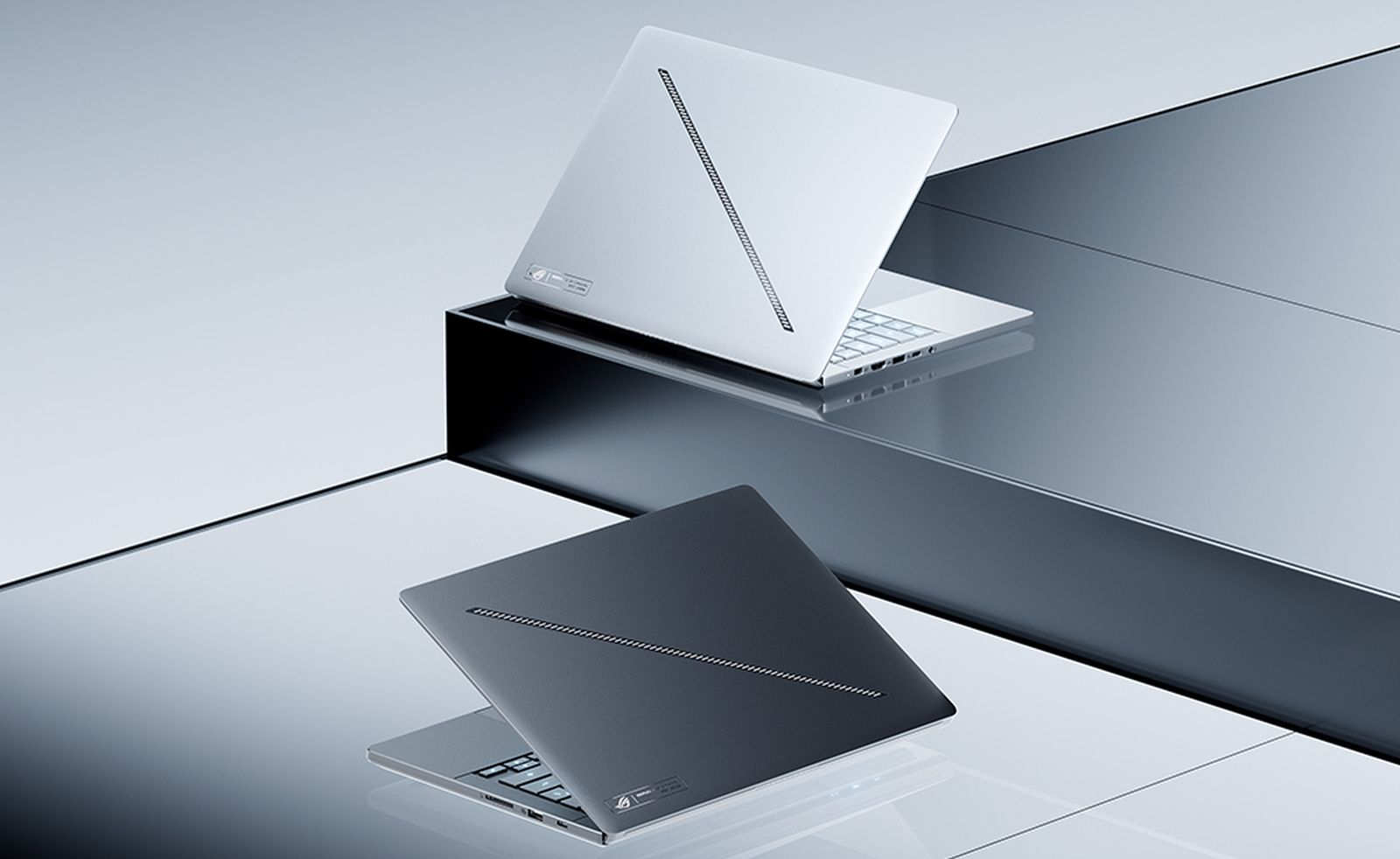 Zwei silberne Laptops stehen auf reflektierenden, geometrischen Oberflächen.