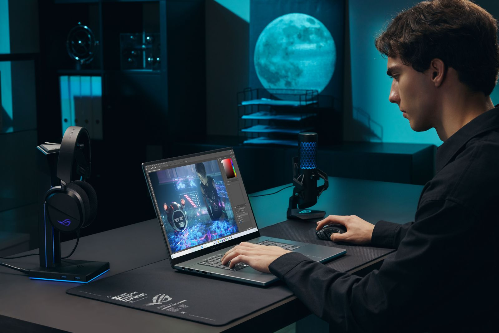 Ein junger Mann arbeitet an einem Laptop in einem bläulich beleuchteten Raum mit Mikrofon und Kopfhörern.