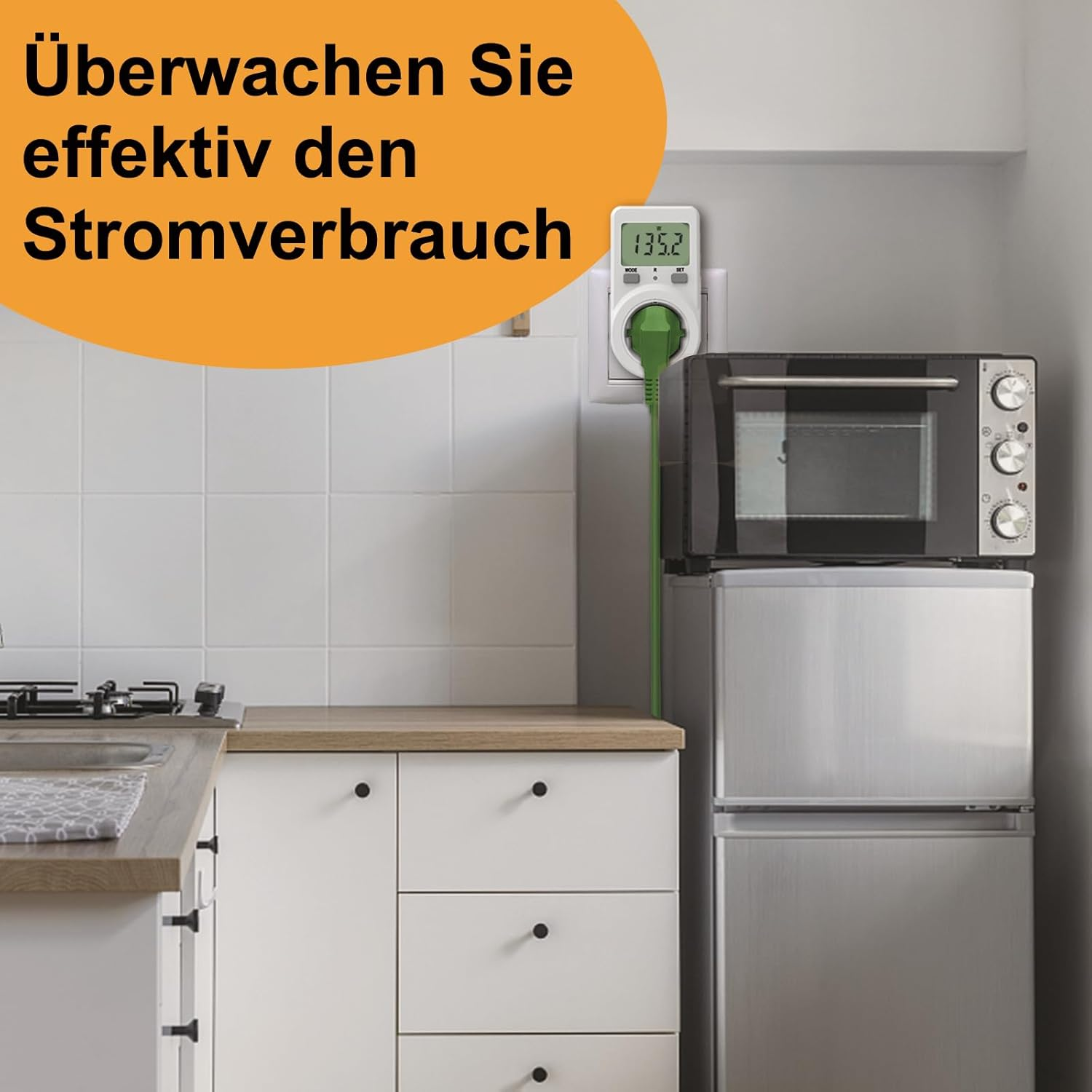 Ein Strommessgerät in einer Küchensteckdose mit grünem Kabel über einem Ofen.