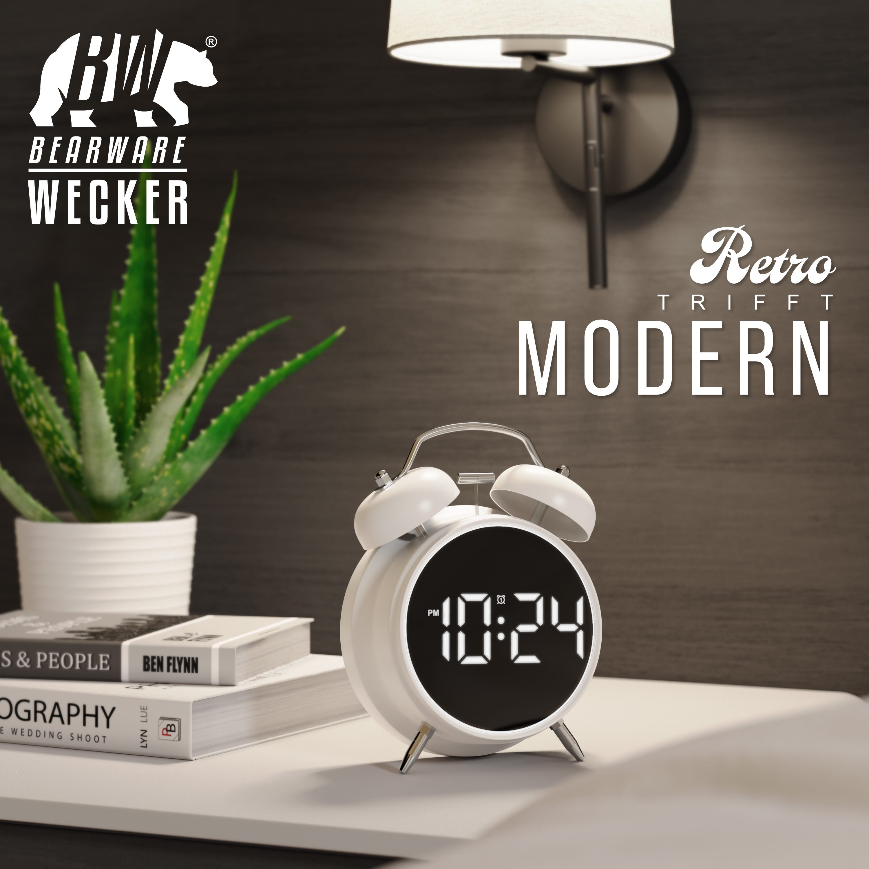 Weißer Retro-Wecker auf einem Tisch neben Büchern und einer Pflanze.