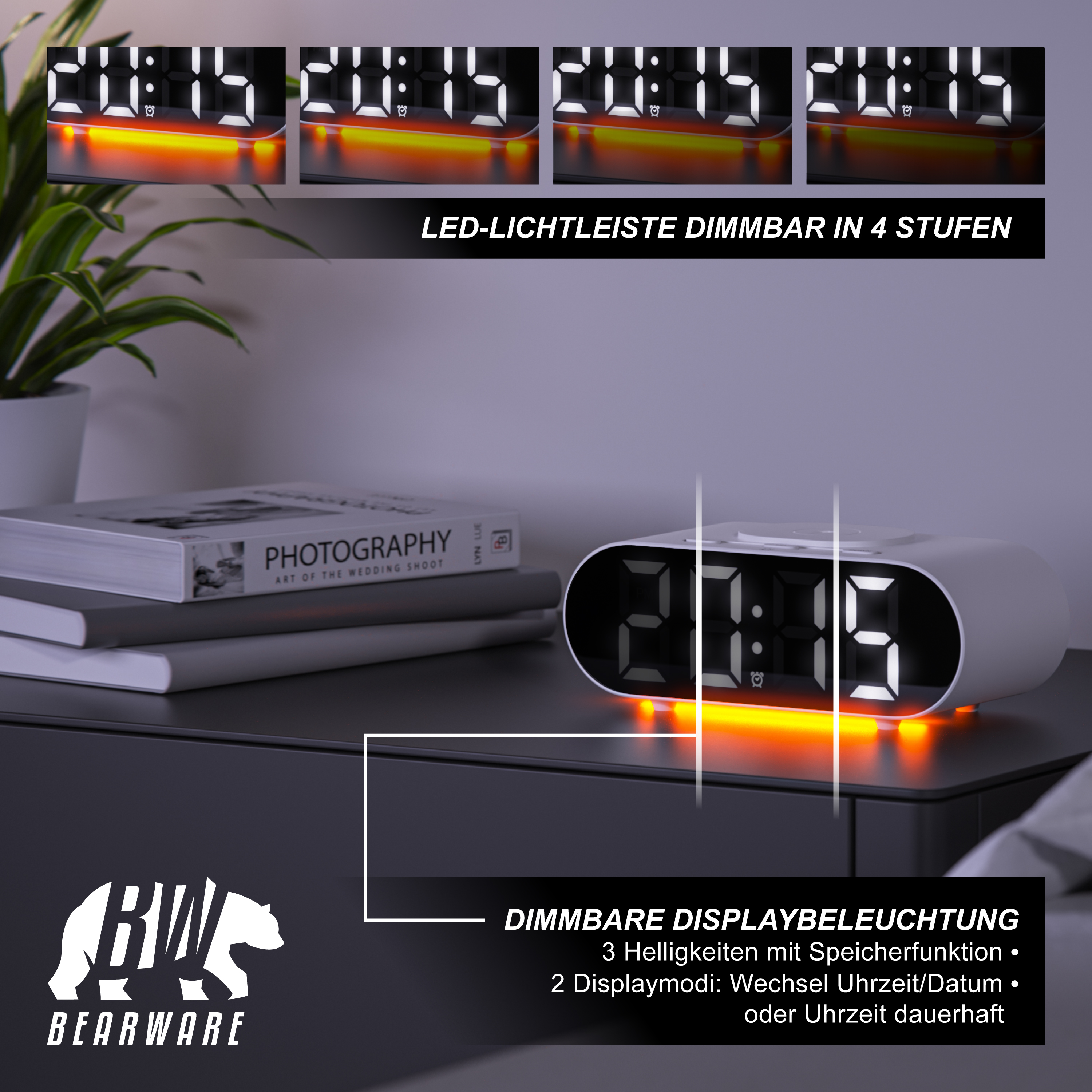 Ein weißer LED-Digitalwecker auf einem Tisch neben Büchern und einer Pflanze, mit dimmbarer Anzeige und Beleuchtung.