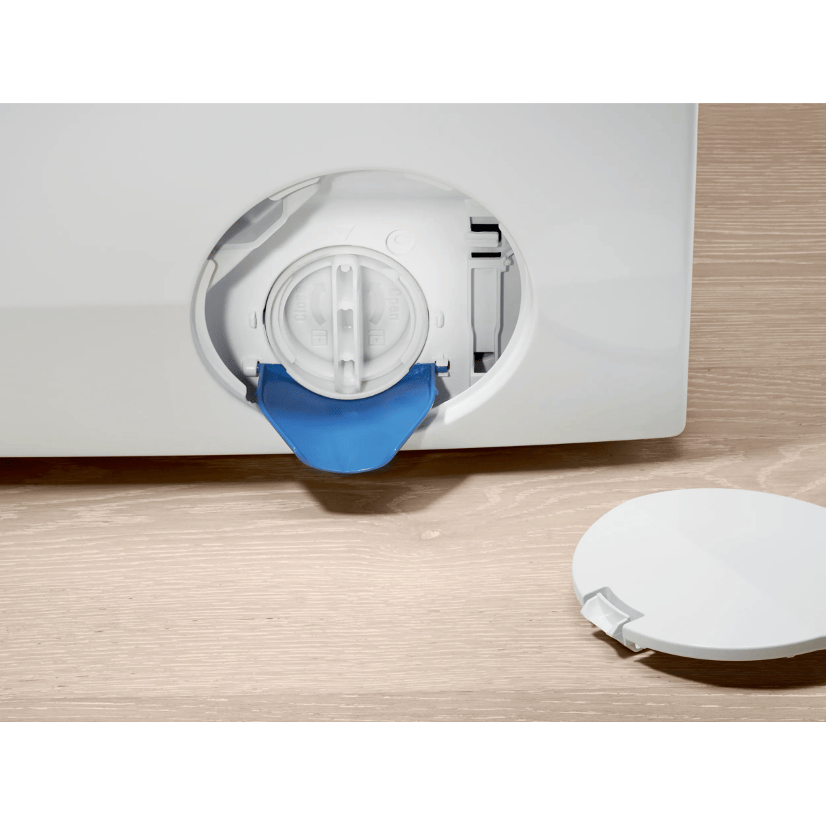 Filtro pompa di scarico aperto con imbuto blu e coperchio bianco rimosso su pavimento in legno.