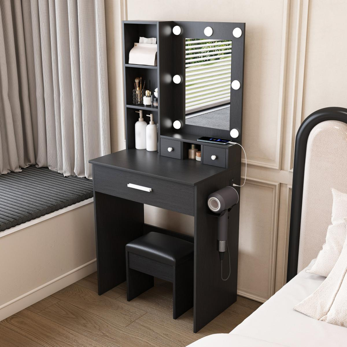 Ein schwarzer Schminktisch mit beleuchtetem Spiegel, Regal, Hocker und angeschlossenem Föhn in einem Schlafzimmer.
