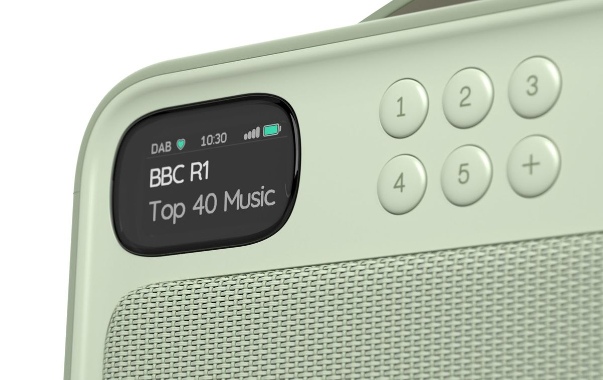 Radio verde claro con pantalla digital que muestra BBC R1, botones numerados y rejilla de altavoz.