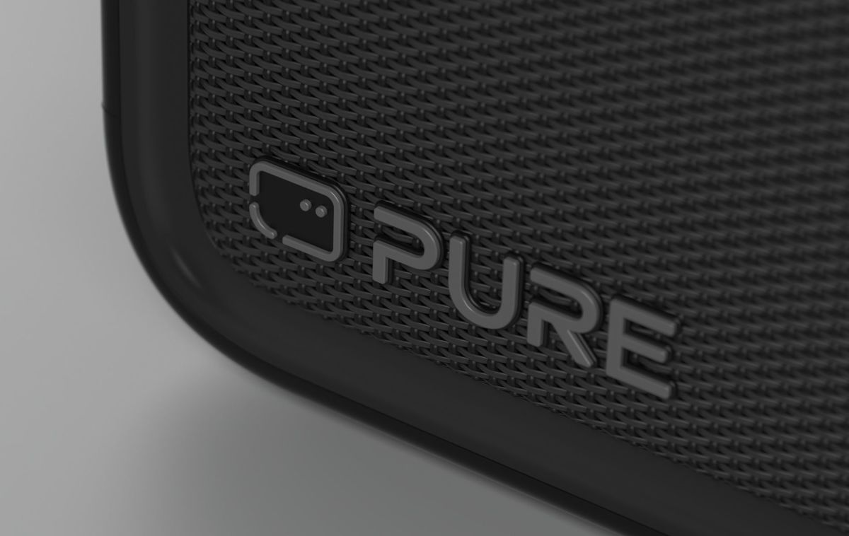 El logotipo gris de Pure en una rejilla de altavoz negra.