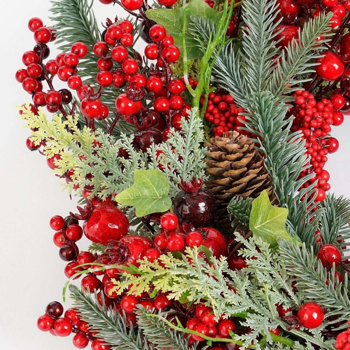 Guirlande de Noël avec baies rouges, pommes de pin, aiguilles de pin et feuilles de lierre.