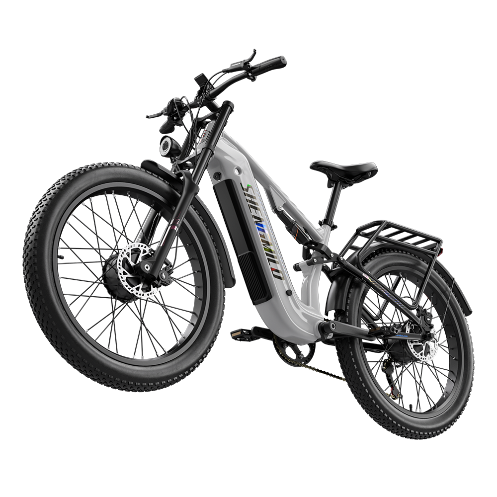Ein weißes Elektro-Fahrrad mit dicken Reifen und Gepäckträger vor schwarzem Hintergrund.