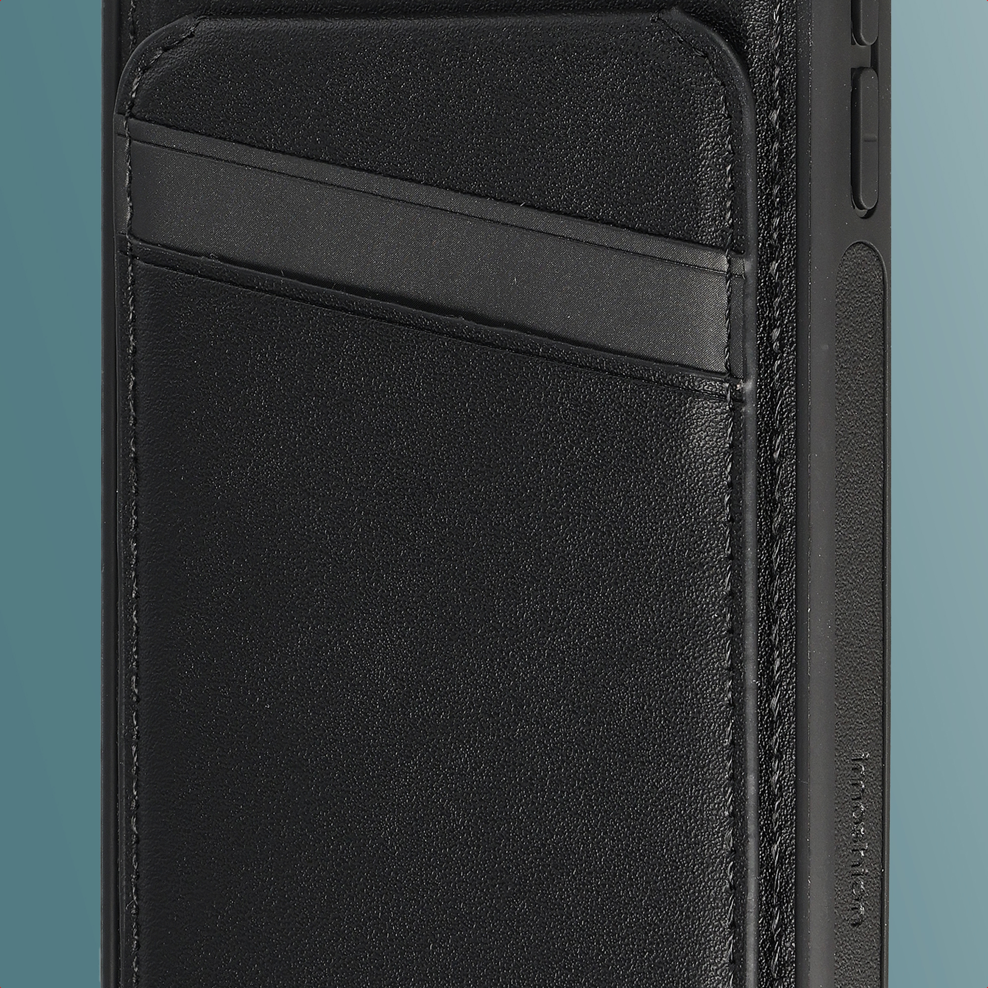 Close-up of a black leather phone case with an integrated card pocket on the back against a teal background.