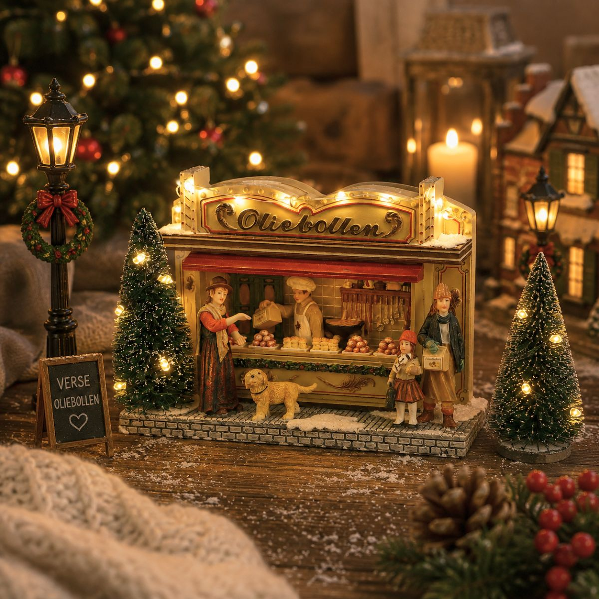 Eine beleuchtete Weihnachtsdorf-Miniatur zeigt einen Oliebollen-Stand mit Figuren, Tannenbäumen und Lichtern.