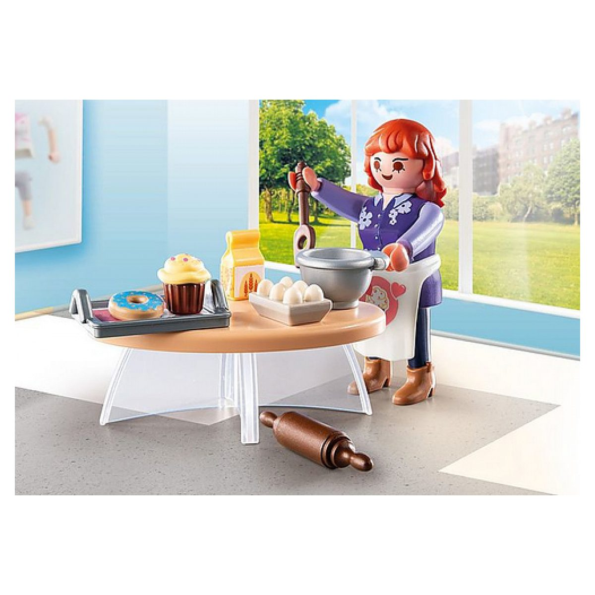 Playmobil-Frau beim Backen in einer Küche mit Tisch, Schüssel, Eiern, Muffin und Nudelholz auf dem Boden.
