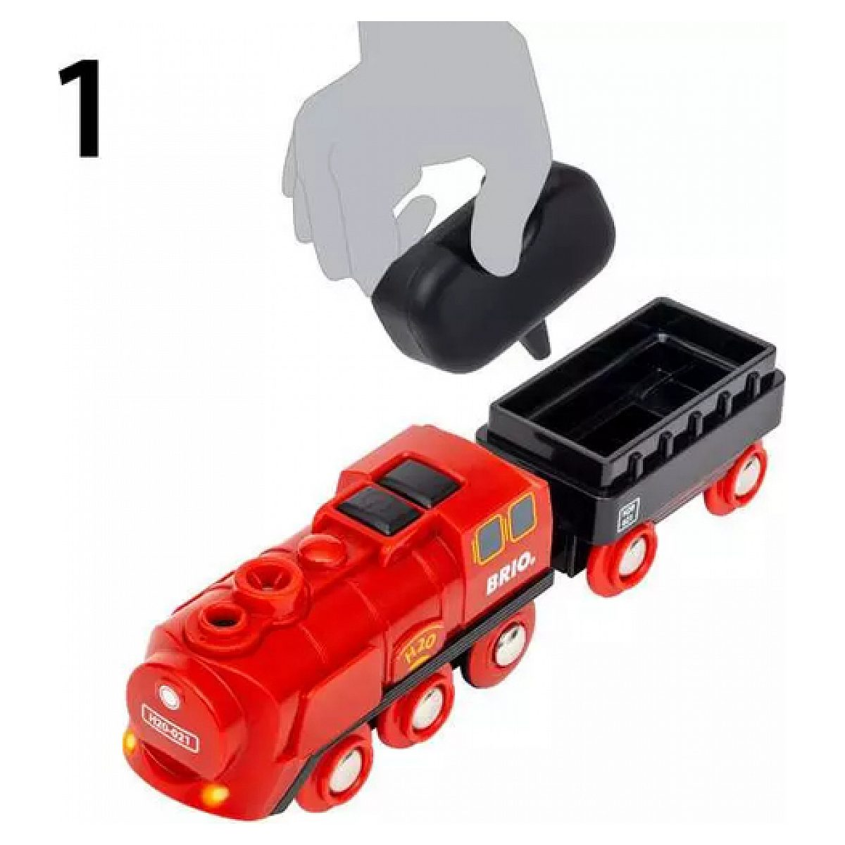 Eine Hand hält ein schwarzes Bauteil über eine rote Brio-Spielzeugeisenbahn mit angehängtem schwarzen Wagen.