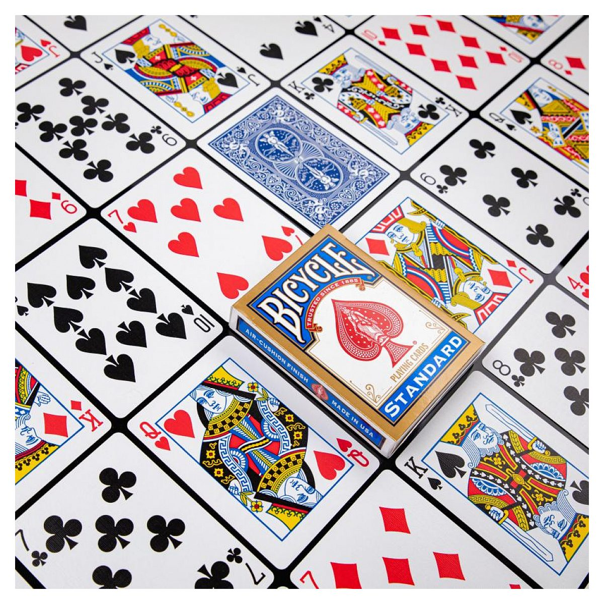 Varias cartas de juego extendidas y una caja de cartas sellada sobre fondo blanco.