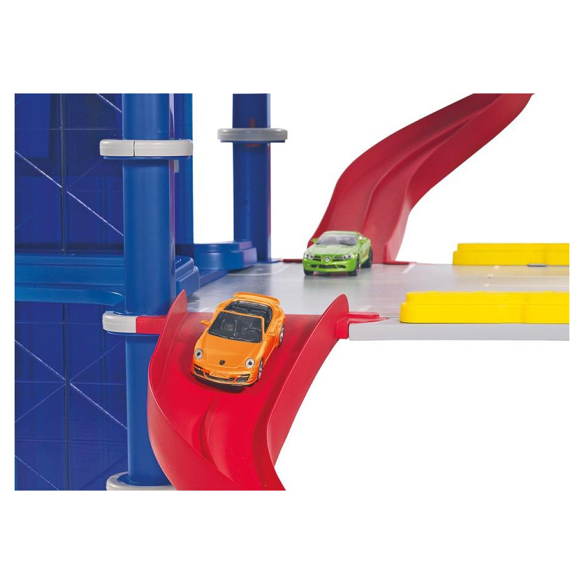 Ein orangefarbenes Spielzeugauto fährt auf einer roten Rampe, ein grünes Auto steht auf der grauen Plattform dahinter.