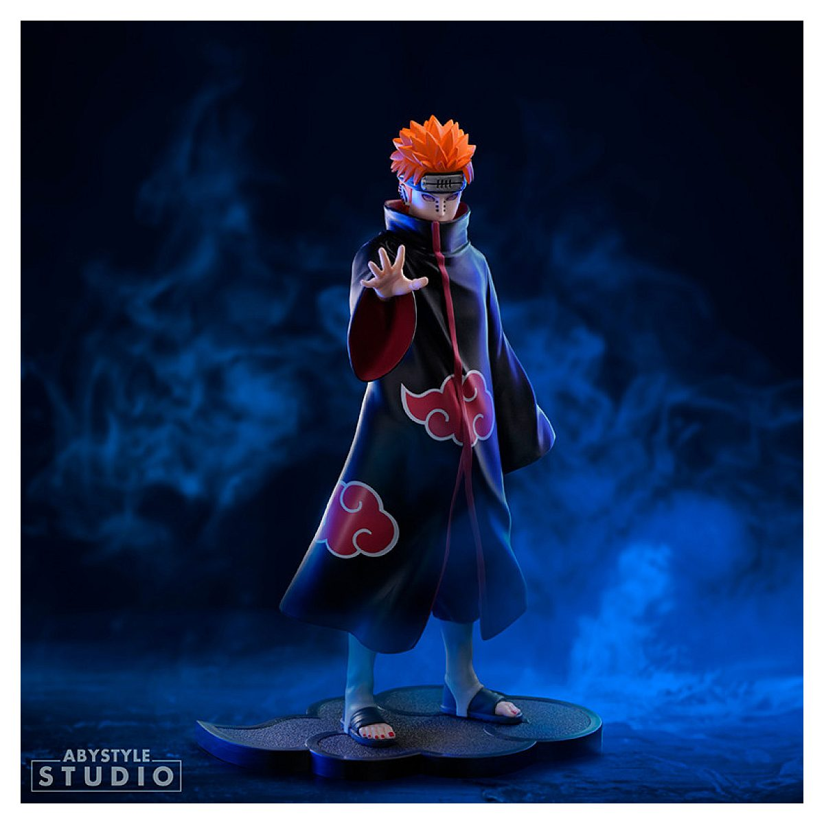 Anime-Figur Pain mit rotem Haar in schwarzem Akatsuki-Mantel mit roten Wolken auf blauem Hintergrund.