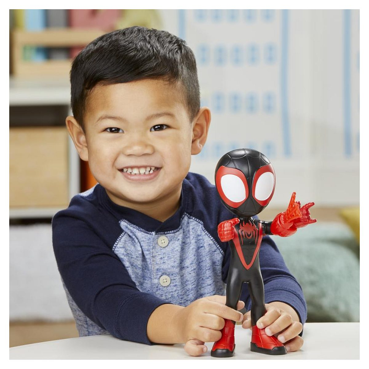 Un niño sonriente sosteniendo una figura de acción de Spider-Man.