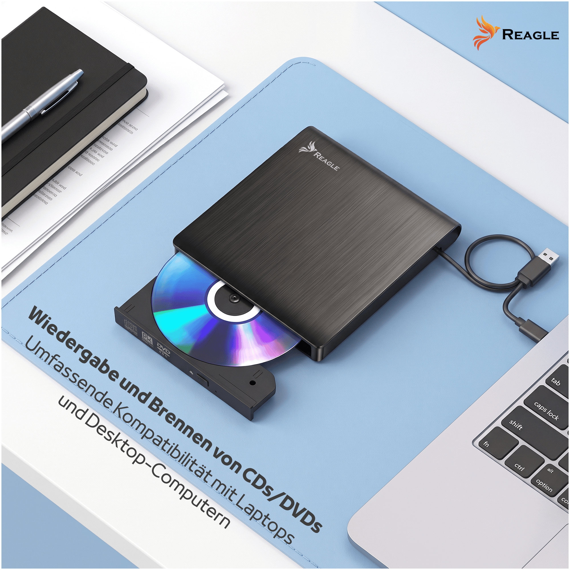 Ein schwarzes Reagle externer CD-DVD-Laufwerk auf einem Schreibtisch mit Laptop und Notizbuch.