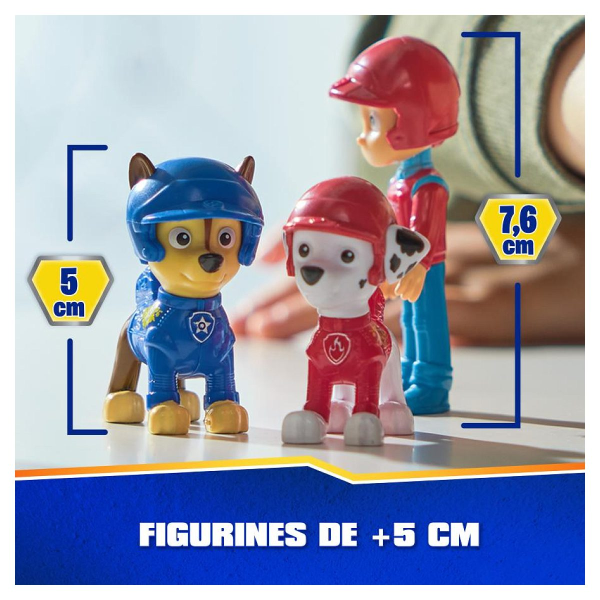Drei Paw Patrol Figuren auf einer Oberfläche, zwei Hunde und eine Person, mit Höhenmarkierungen von 5 cm und 7,6 cm.