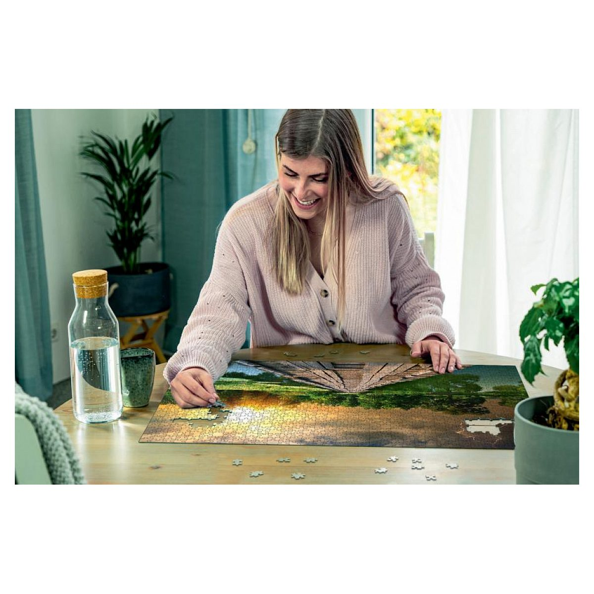 Eine lächelnde Frau sitzt an einem Tisch und setzt ein Puzzle zusammen.