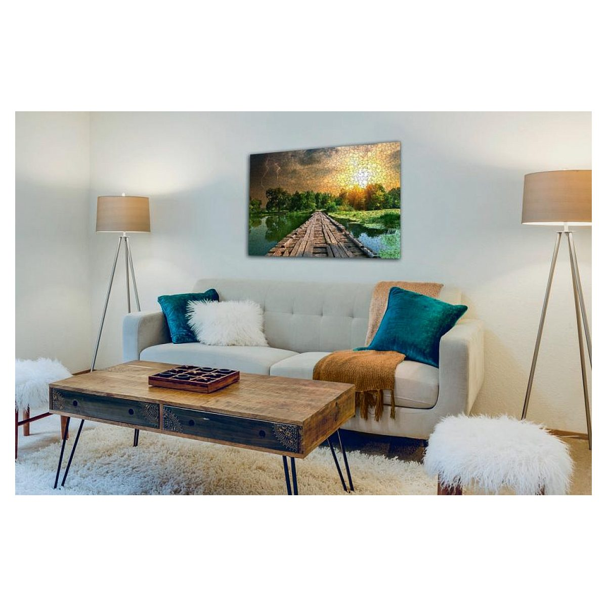 Ein hell erleuchtetes Wohnzimmer hat ein weißes Sofa, einen Holztisch, zwei Lampen und ein Landschaftsbild an der Wand.