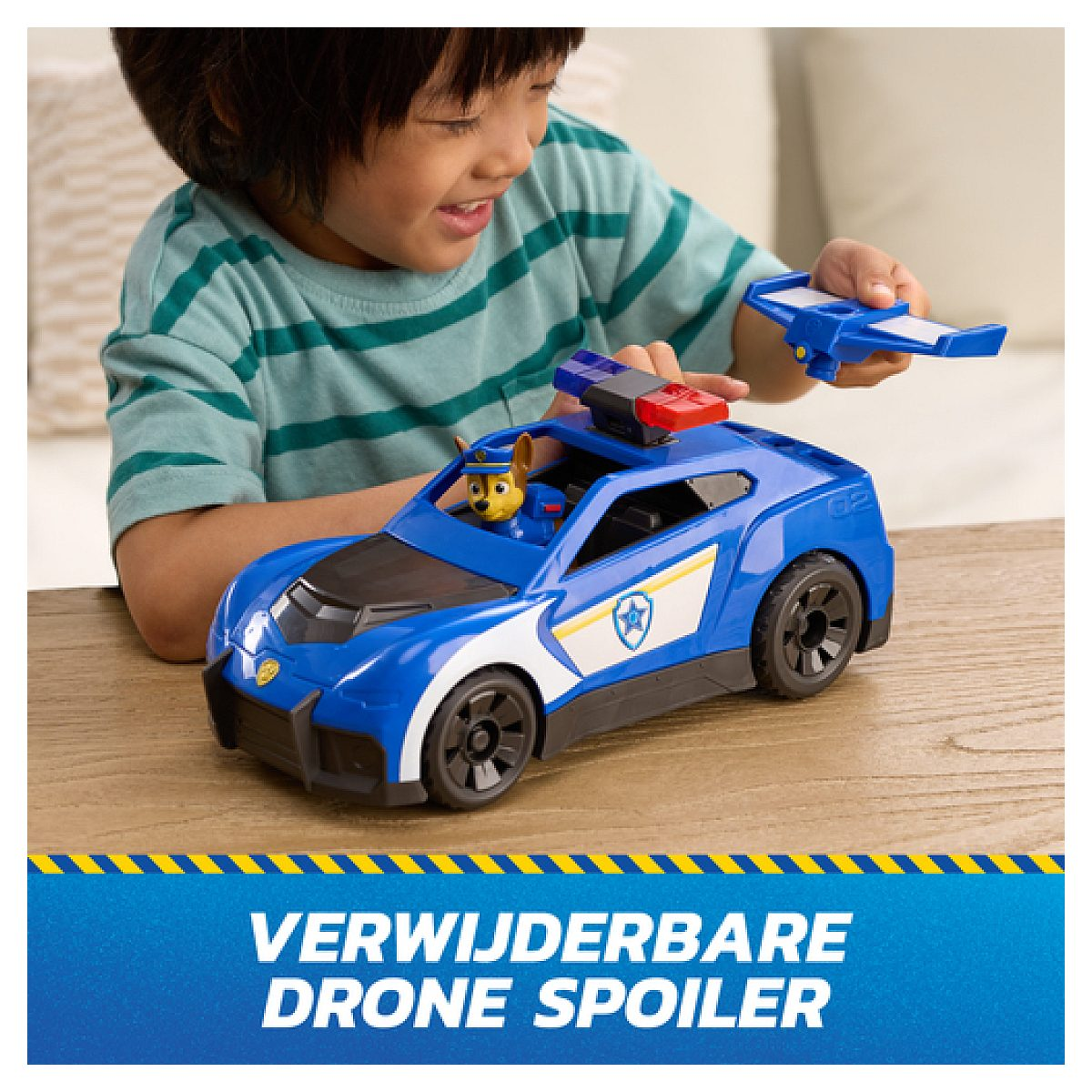 Un niño juega con un coche de policía de juguete azul con una figura de Chase y alerón de dron.