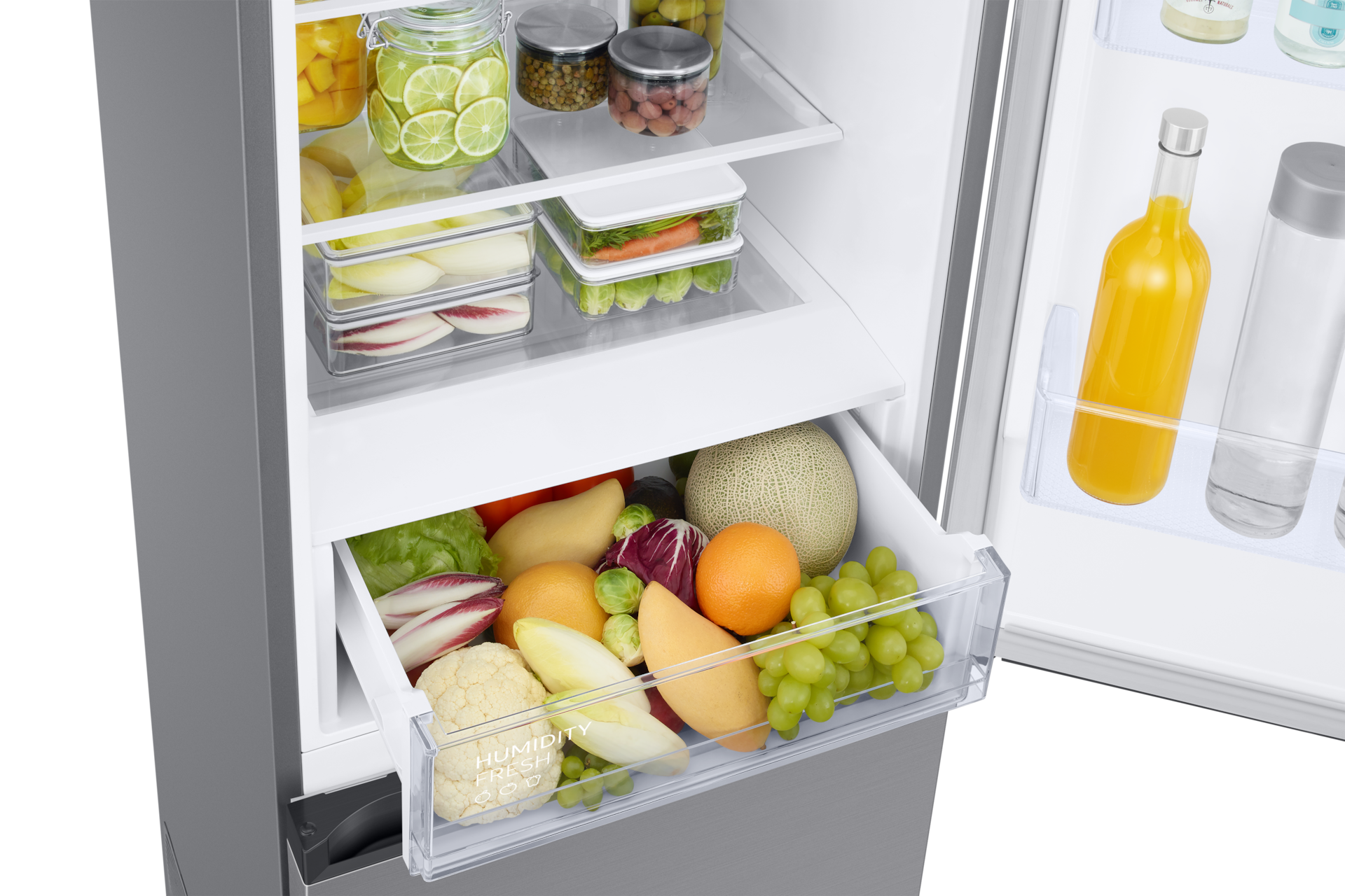 Ein offener Kühlschrank mit gut gefüllten Regalen und einer Obstschublade.