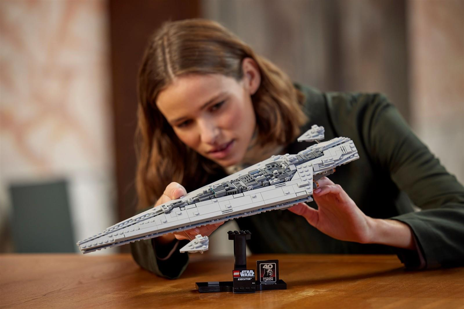Eine Frau betrachtet sorgfältig ein fertiges LEGO Star Wars Executor Super Star Destroyer Modell.