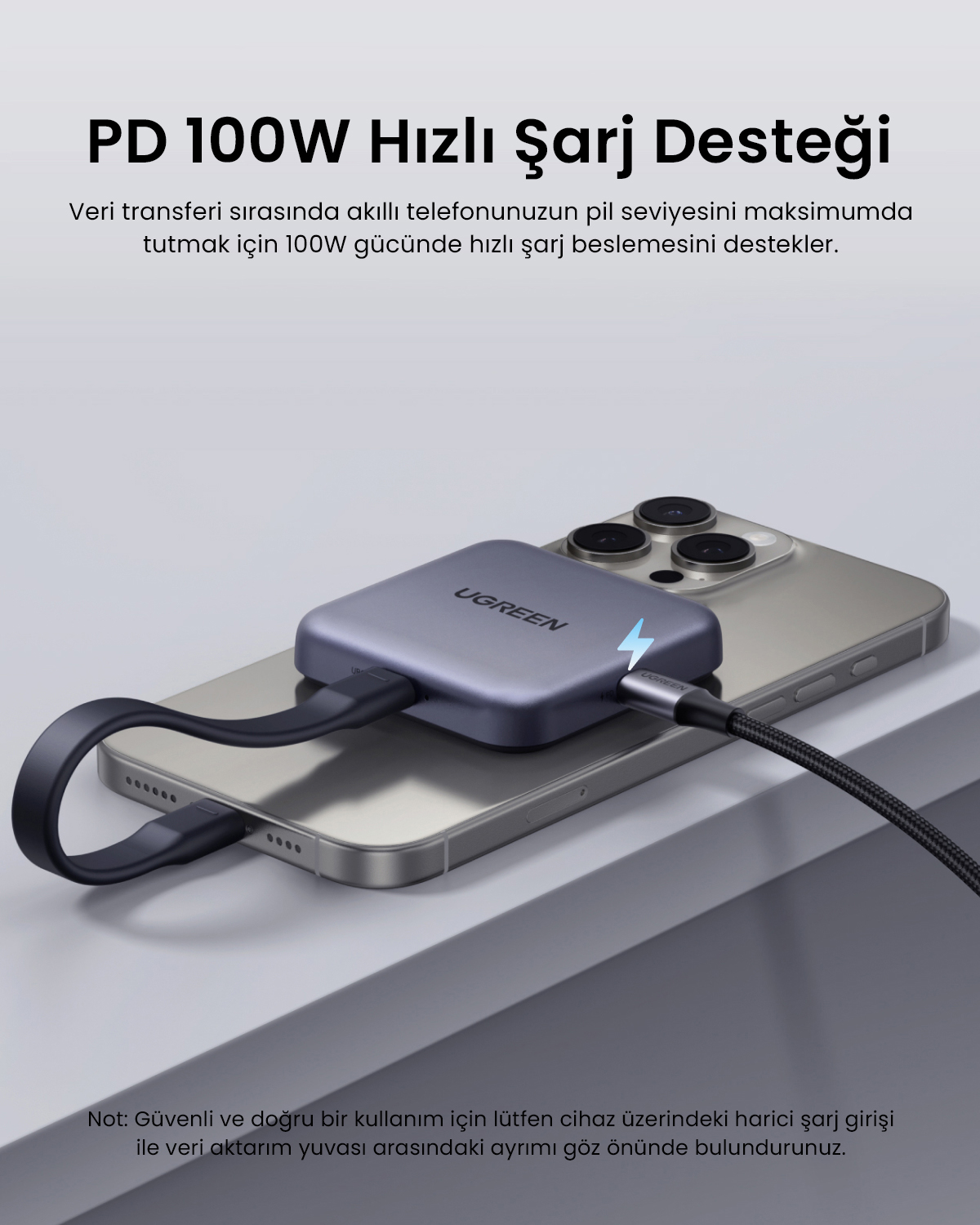 Gri bir UGREEN USB çoklayıcı bir akıllı telefonun üzerinde duruyor, kablolarla bağlı, üst ve altta metin var.