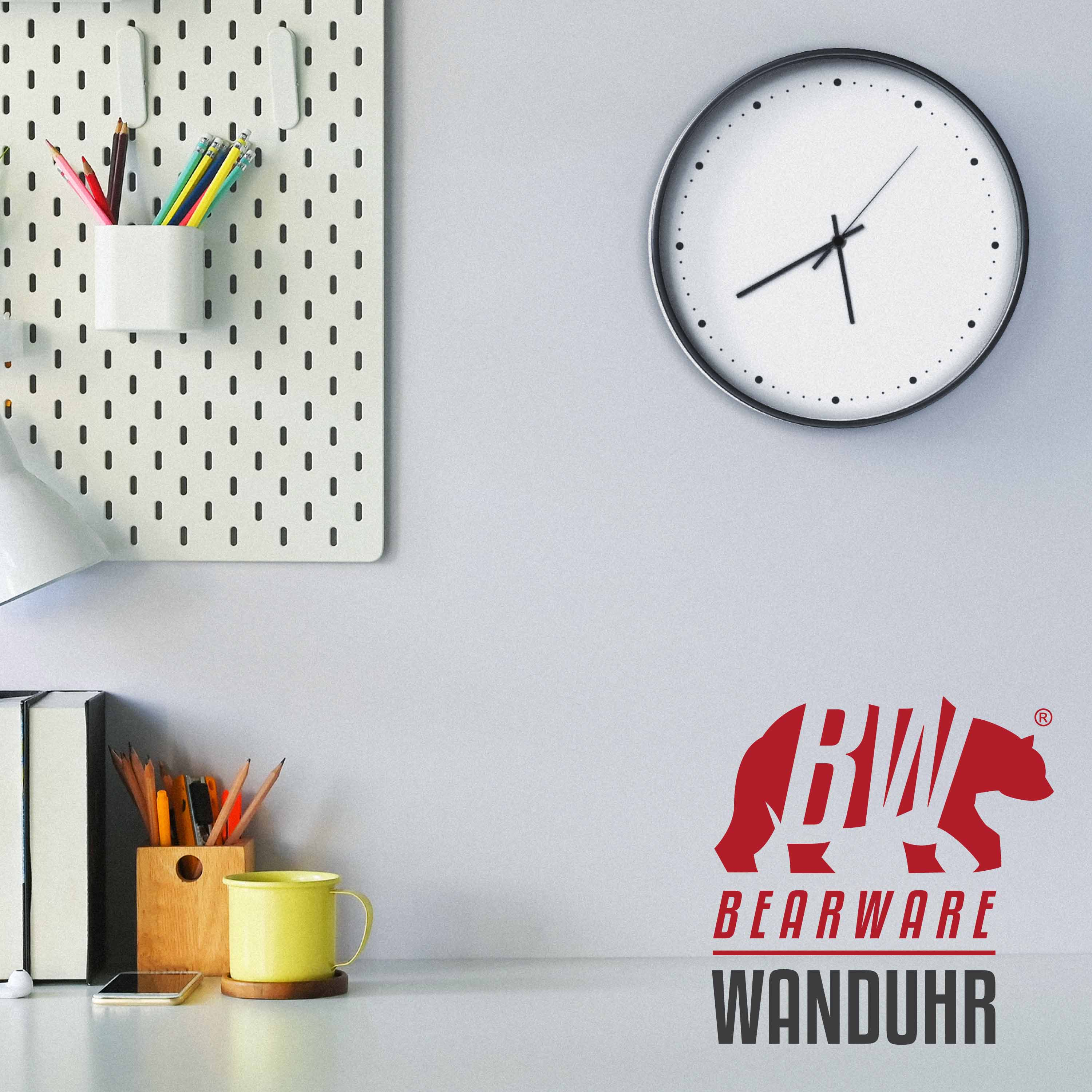 Eine weiße Wanduhr hängt neben einer Stecktafel und Schreibwaren auf einem Schreibtisch.
