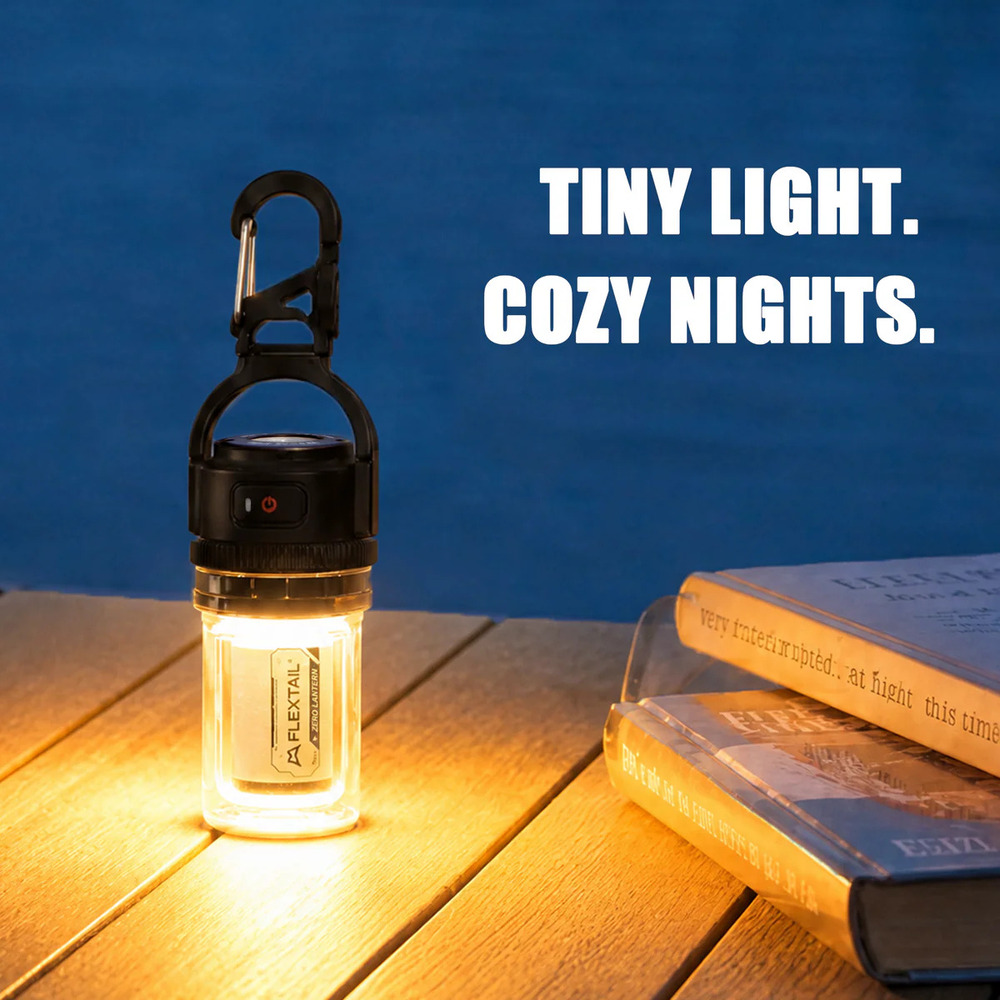Eine kleine LED-Laterne leuchtet auf einem Holzdeck neben Büchern, mit Text im Hintergrund.