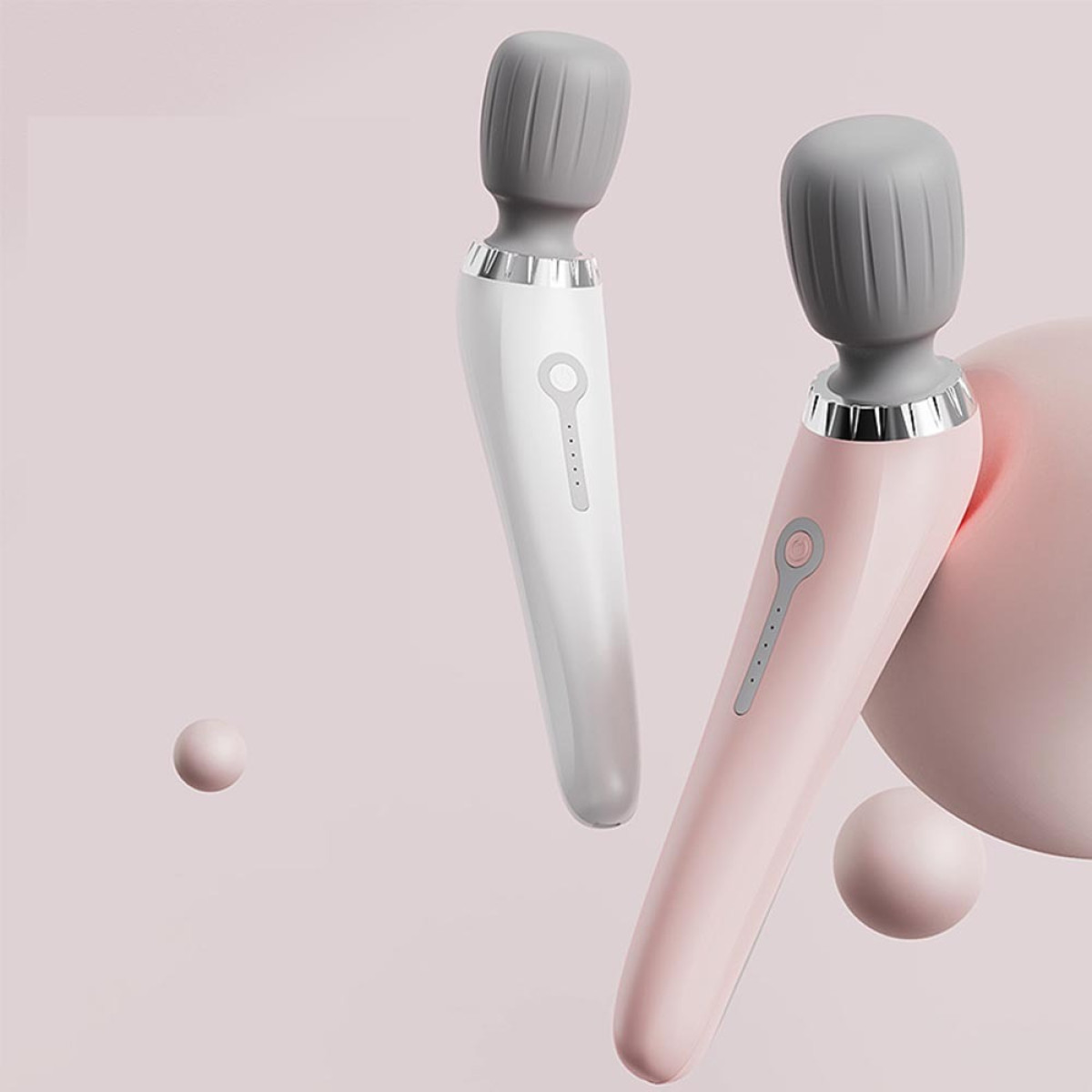 Zwei Stabmassagegeräte in Weiß und Rosa vor sanftem rosa Hintergrund mit schwebenden Kugeln.