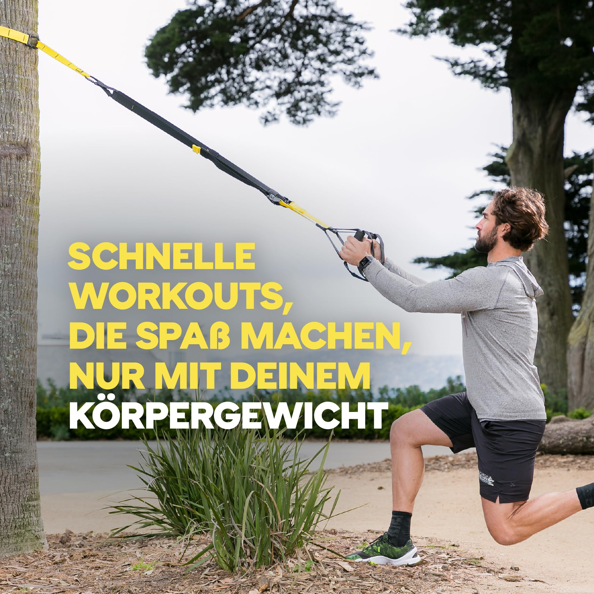 Ein Mann macht Ausfallschritte im Freien mit TRX-Gürteln, die an einem Baum befestigt sind.