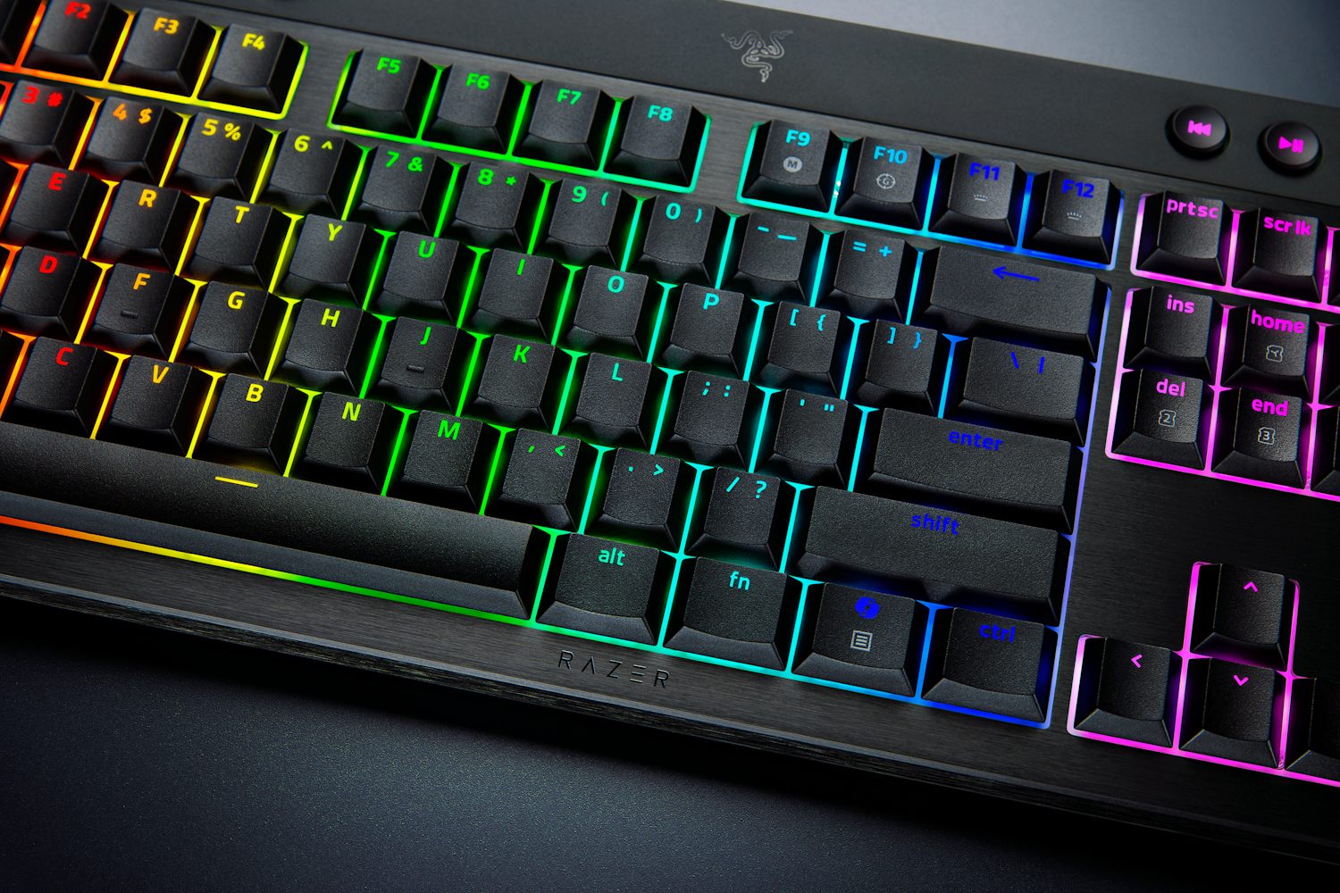 Una tastiera da gioco meccanica nera è dotata di una vivace retroilluminazione arcobaleno che illumina ogni tasto.