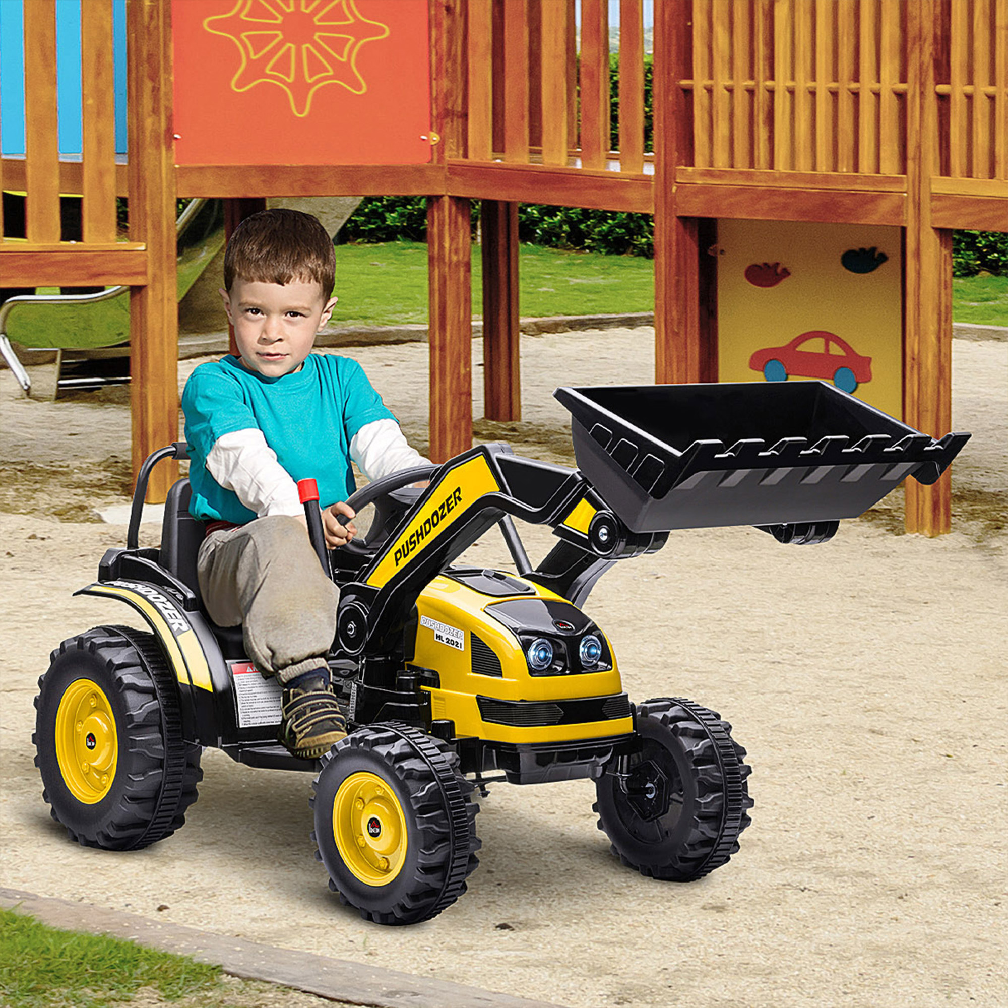 Un bambino siede su un bulldozer giocattolo giallo con benna nera su sabbia in un parco.