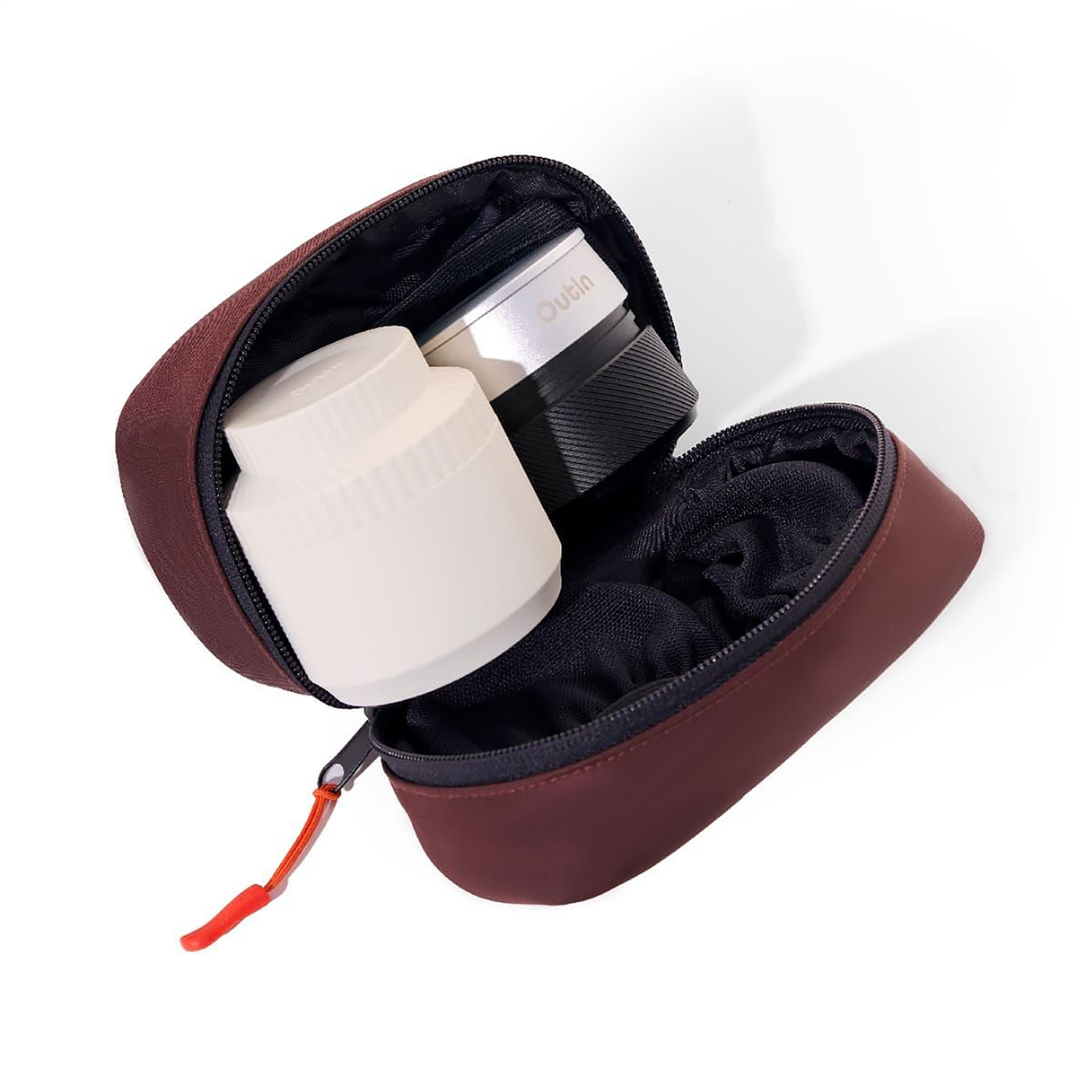 Un estuche de viaje marrón abierto que contiene una taza de café blanca y un molinillo de café.