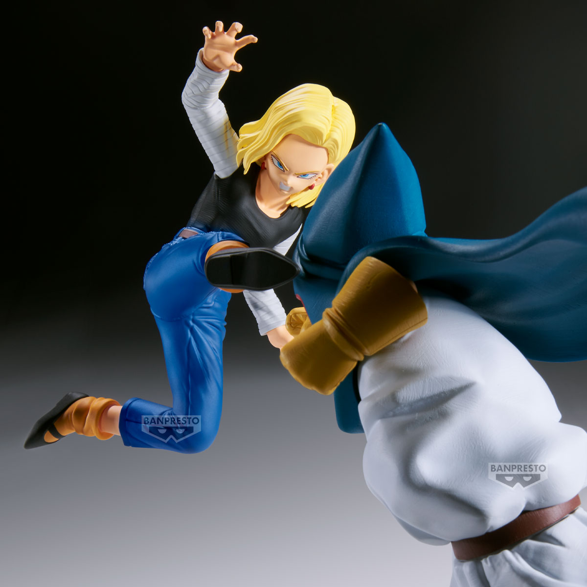 Action figure di Android 18 che esegue una mossa di combattimento, scalciando contro una figura con mantello blu.
