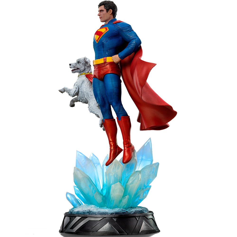 La statuetta di Superman con Krypto fluttua sopra cristalli blu su una base rotonda.
