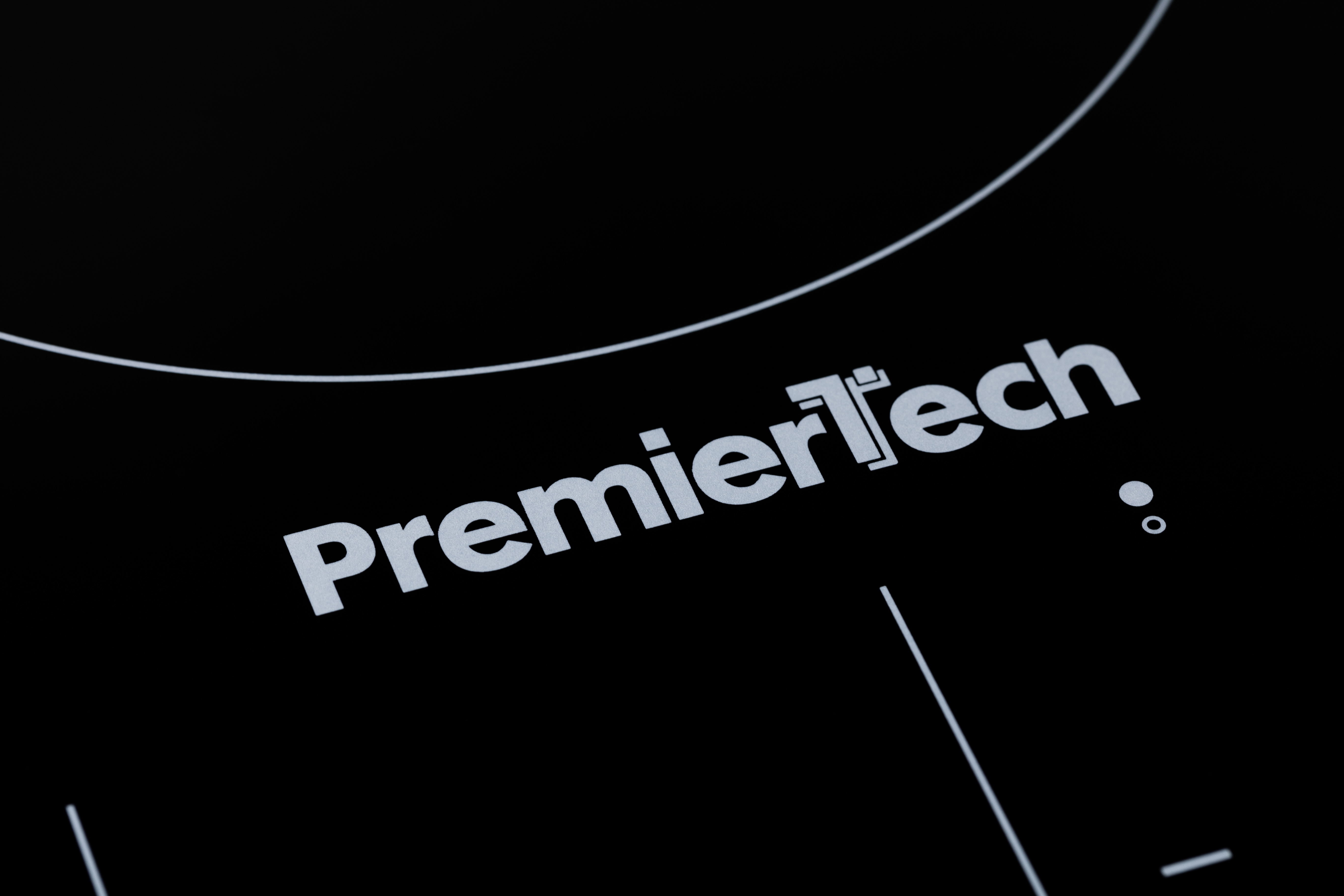 Il testo PremierTech in bianco su una superficie di cottura nera.