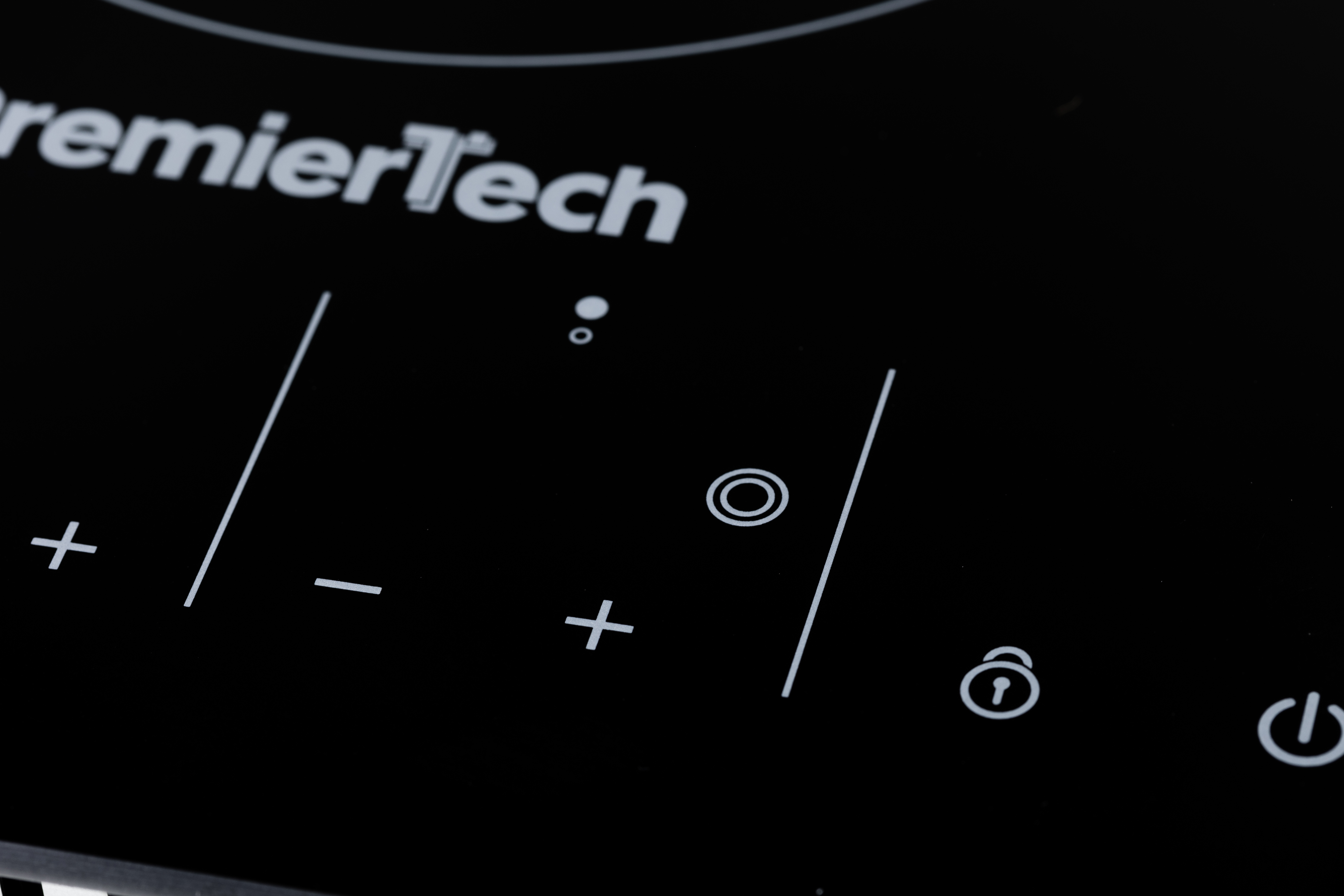 Primo piano di un piano cottura a induzione nero PremierTech con comandi a sfioramento, pulsanti più-meno e icone.