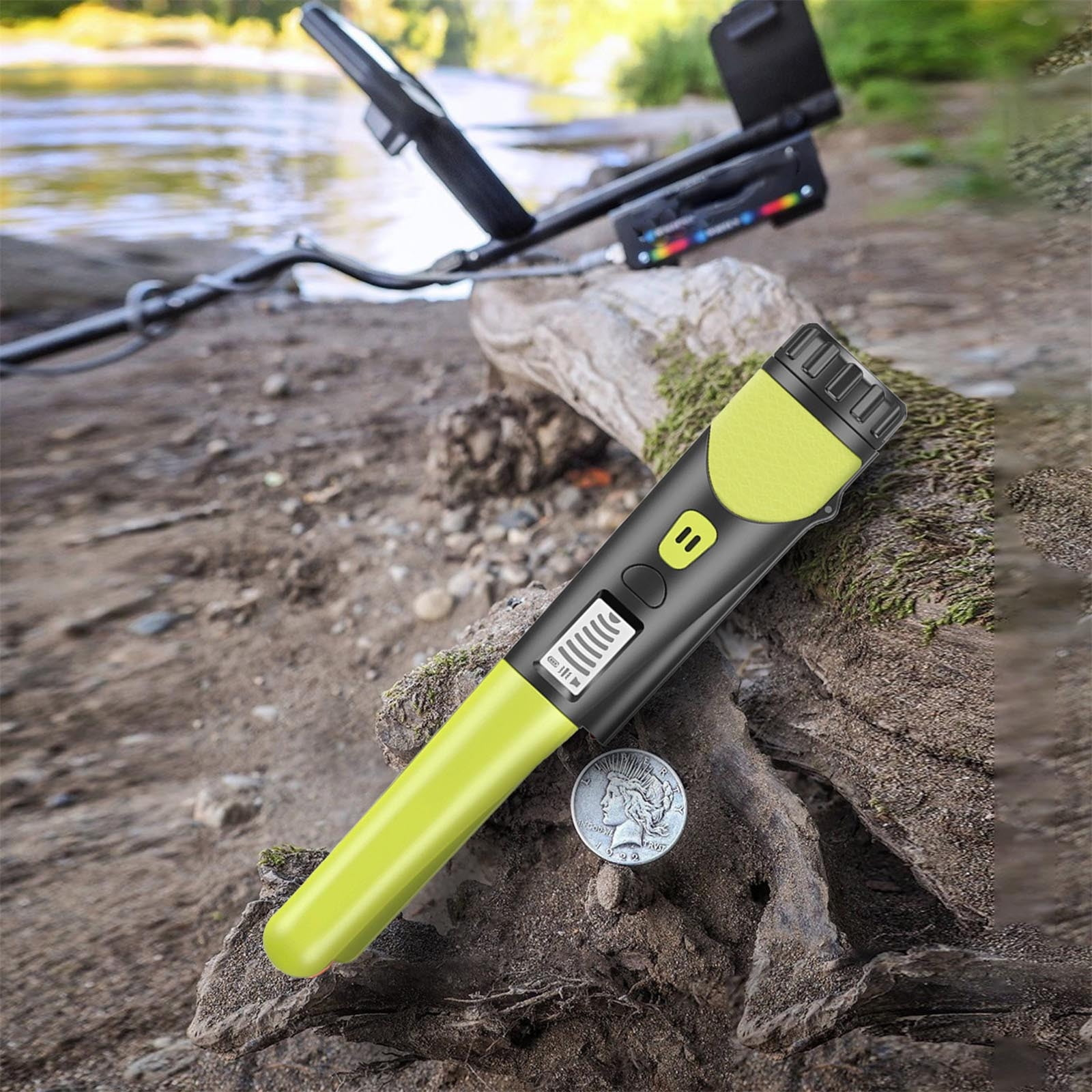 Ein grün-schwarzer Pinpointer und eine Silbermünze liegen auf einem moosigen Ast am Fluss.