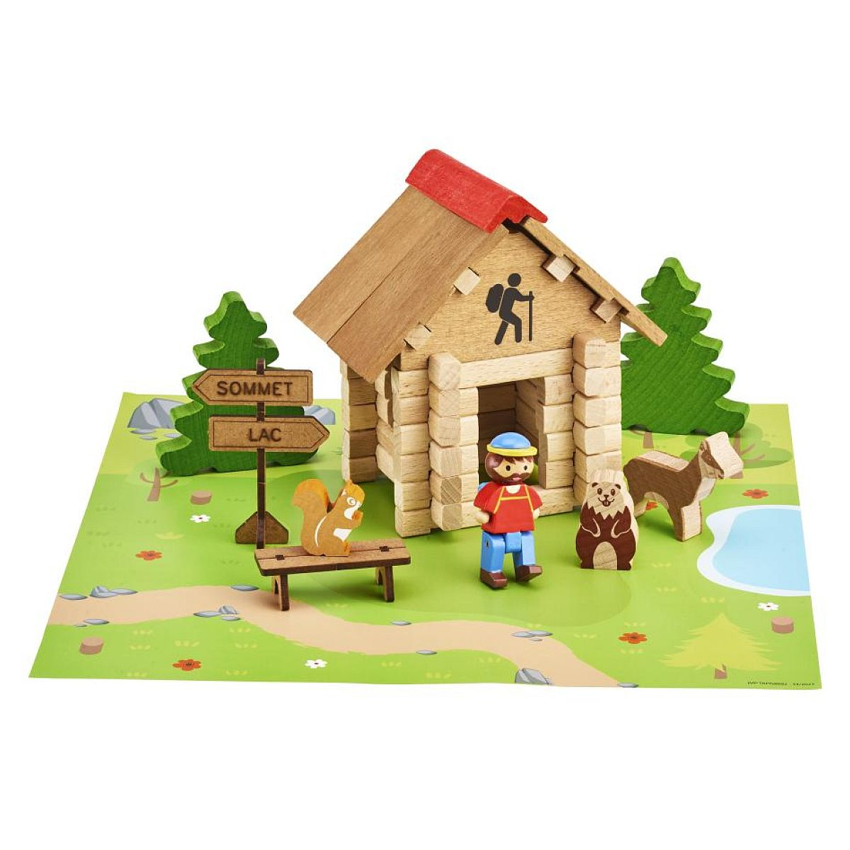Holzhütte mit Wanderer, Tieren und Wegweisern auf einer grünen Spielunterlage.
