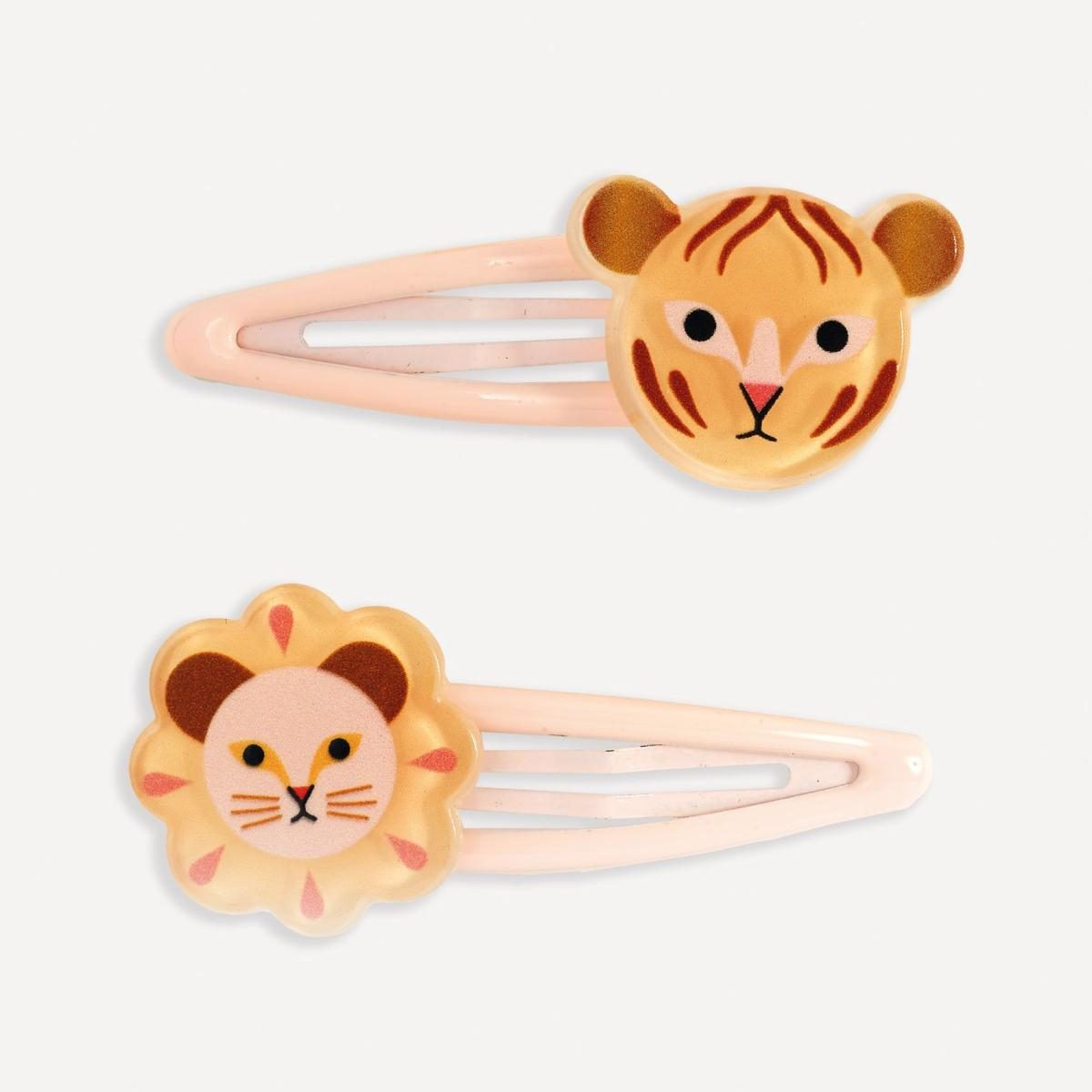 Zwei rosa Haarspangen mit Tiermotiven, eine mit Tigerkopf und eine mit Löwenkopf auf hellem Hintergrund.