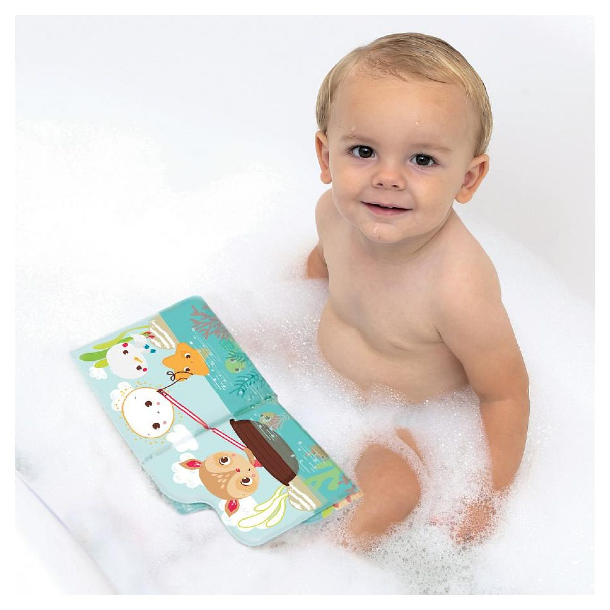 Ein lächelndes Kleinkind sitzt in einer mit Schaum gefüllten Badewanne und hält ein illustriertes Buch.