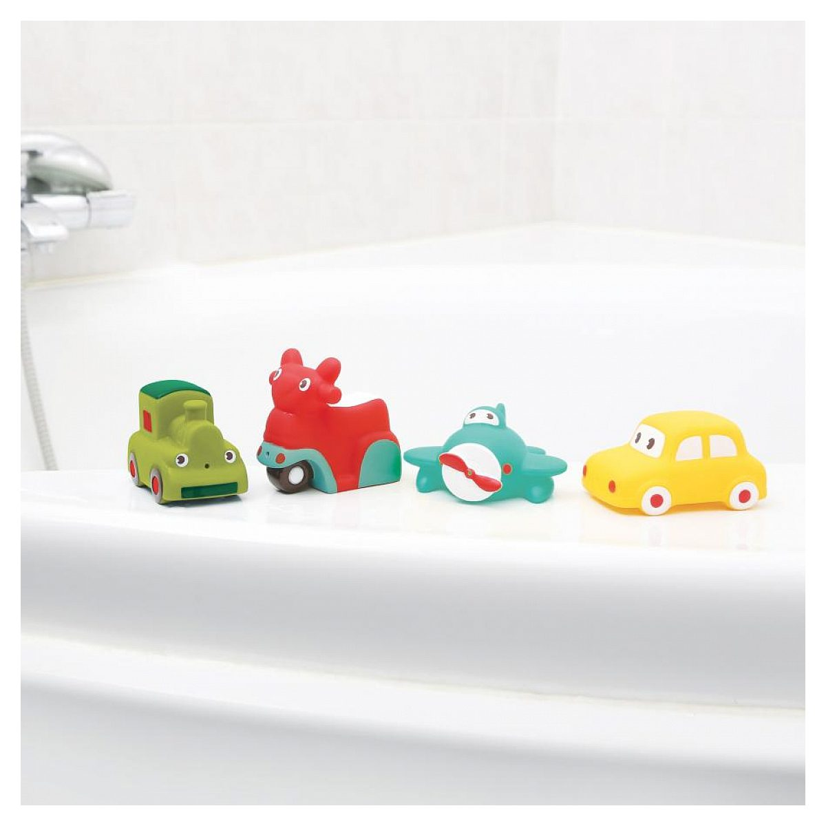 Vier bunte Kinderspielzeug-Fahrzeuge stehen auf dem Rand einer weißen Badewanne.
