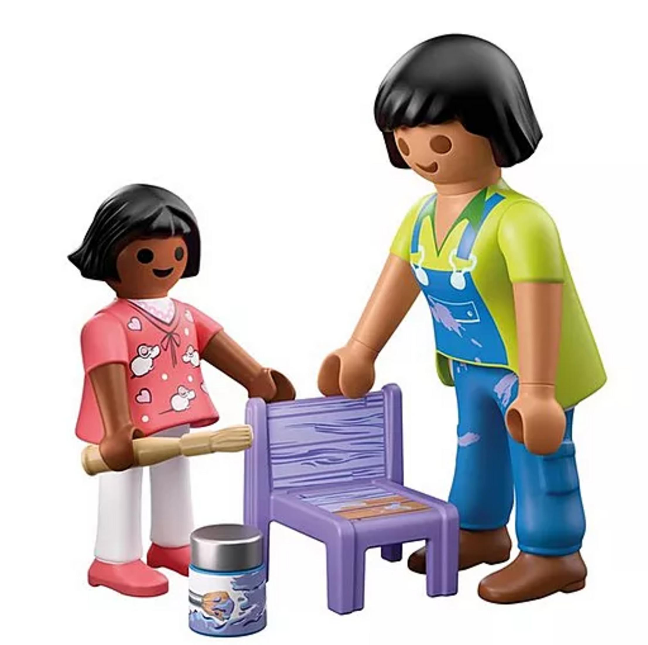 Zwei Playmobil-Figuren streichen einen lila Stuhl, daneben steht ein Farbeimer.
